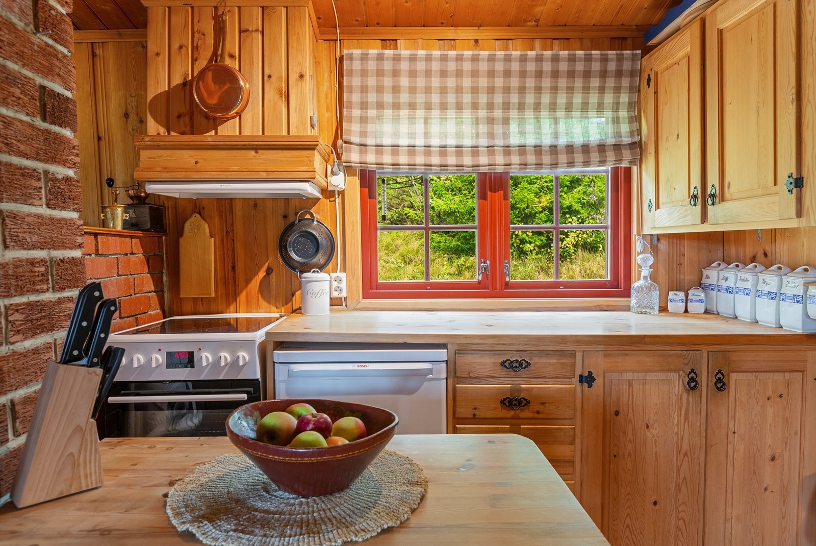 Kjøkkeninnredning med heltre over- og underskap samt benkeplate i heltre. Hvitevarer som komfyr, kjøleskap og ventilator følger med. Galleribilde