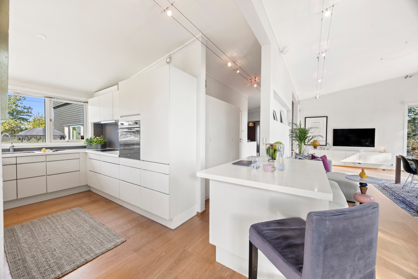 Moderne kjøkkeninnredning med slette fronter og benkeplate i heltre og Corian. Galleribilde