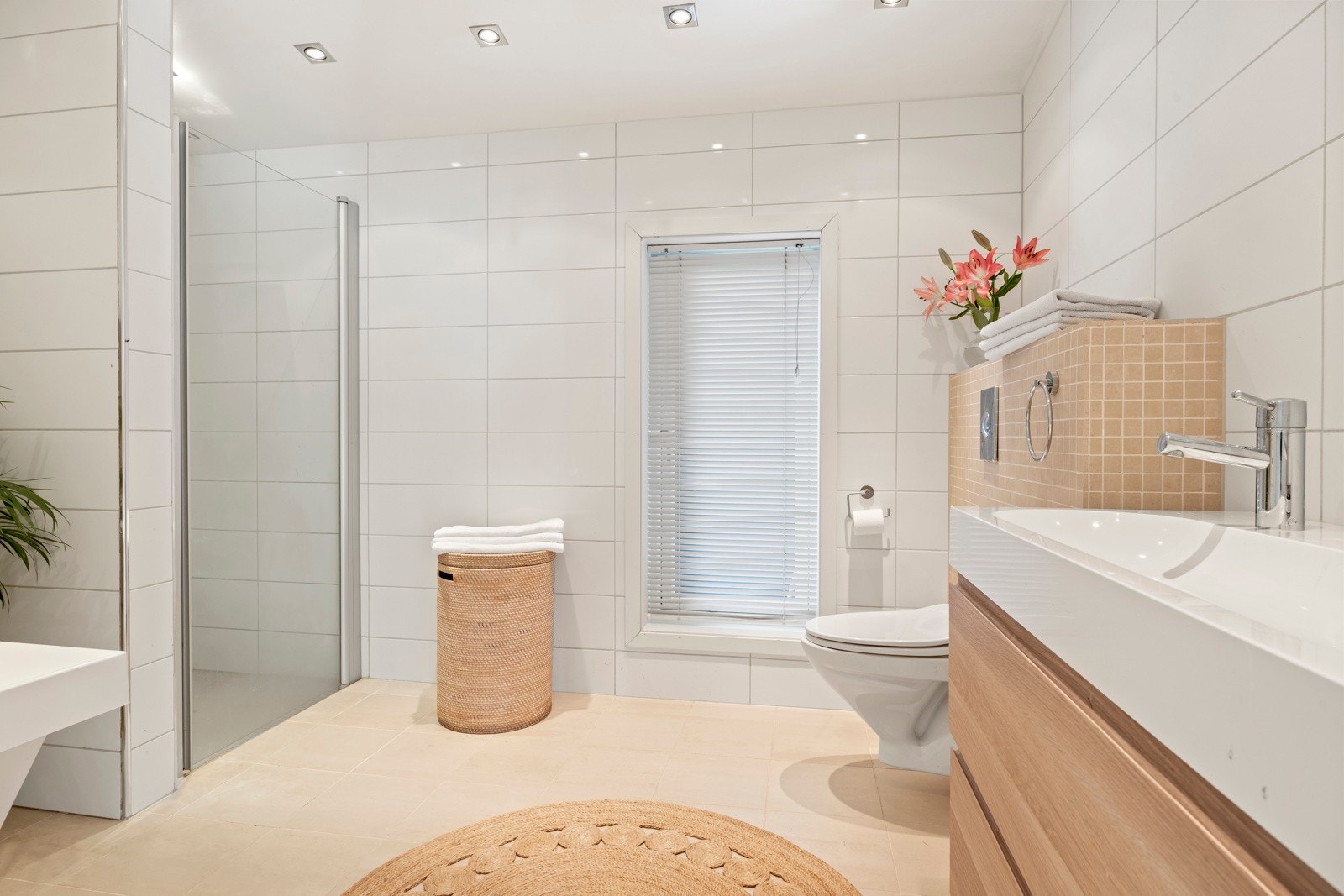 Bad nr. 2. Lyst flislagt baderom innredet med dusjnisje, badekar, dobbel servant med skuffeseksjon og klosett. Galleribilde