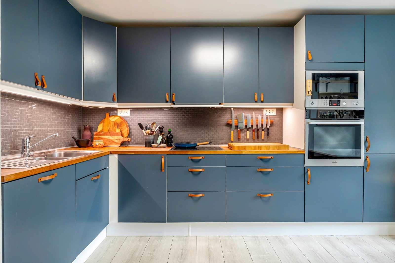 Innredningen fra HTH er oppgradert med fronter lakkert i fargen Deco Blue og elegante håndtak i skinn, kombinert med benkeplater i eik som gir en varm kontrast til de dype blå tonene. Galleribilde