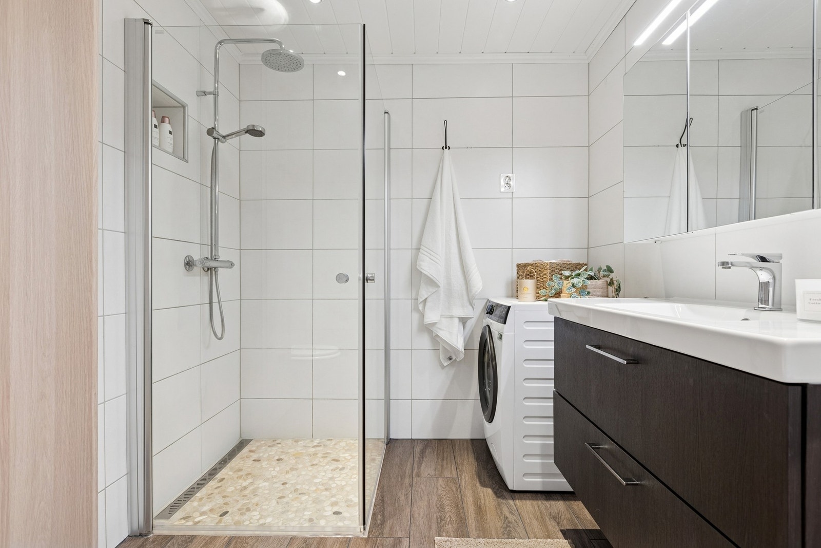 Her får du også en stilren vegghengt servantinnredning og dusjhjørne med dører. Galleribilde