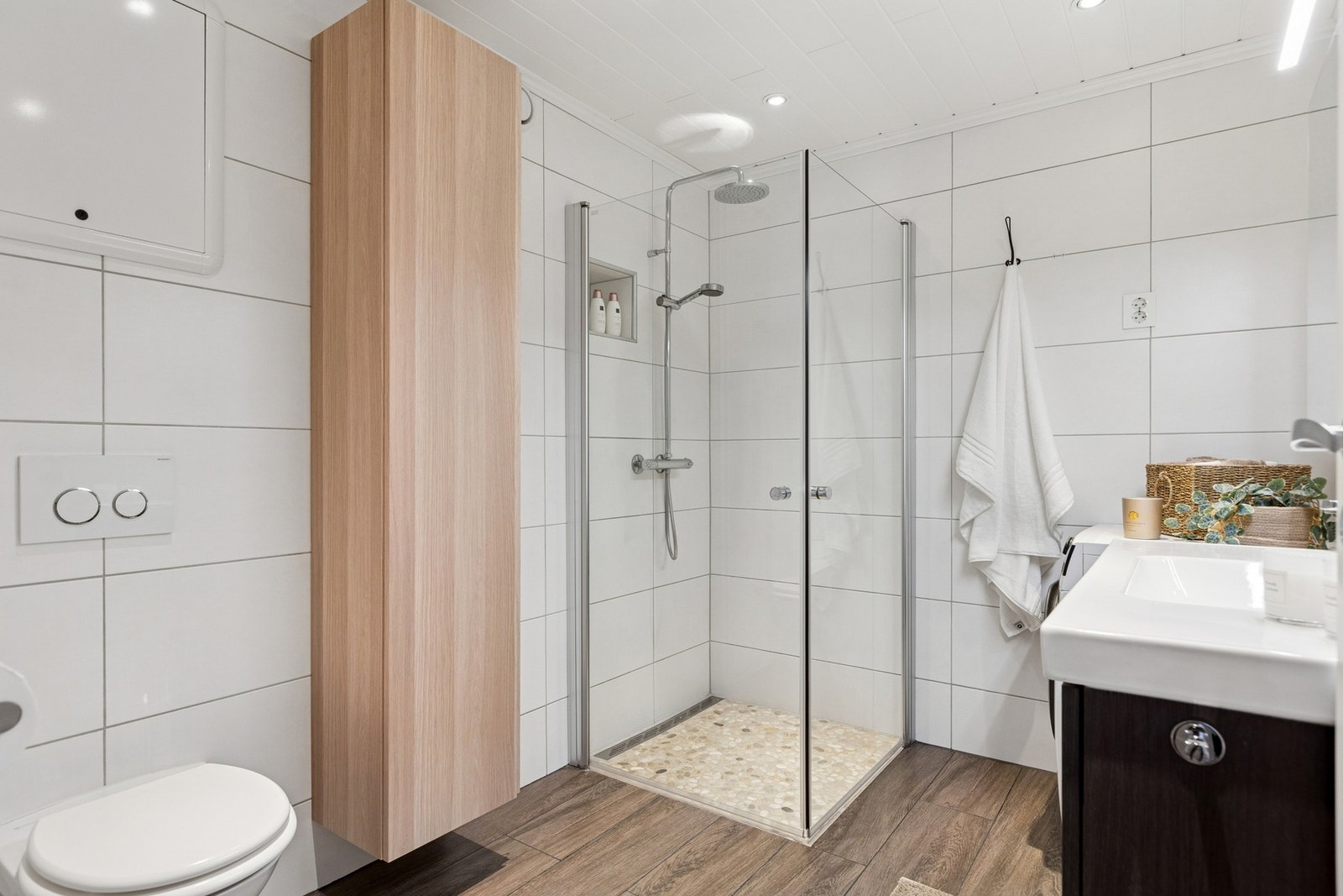 Badet er lyst og moderne med stilrene fliser. Galleribilde