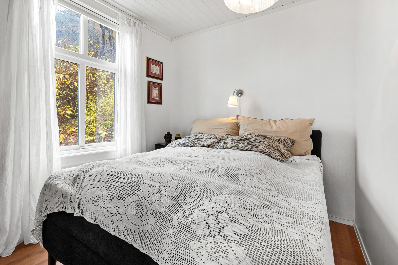 Lyst soverom med laminat på gulv, malt tapet på vegger og panel i himling Galleribilde
