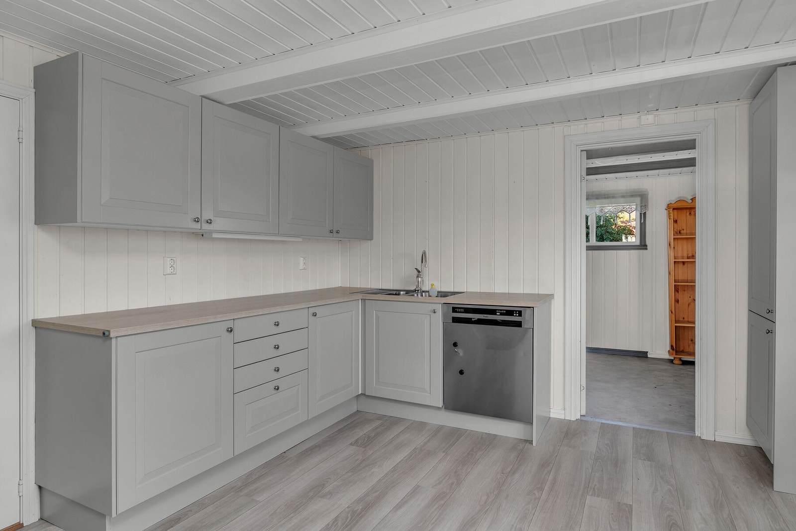 Nyere kjøkkeninnredning med profilerte fronter, benkeplate inkl. stålbeslag med kummer, overskap og underskap. Galleribilde