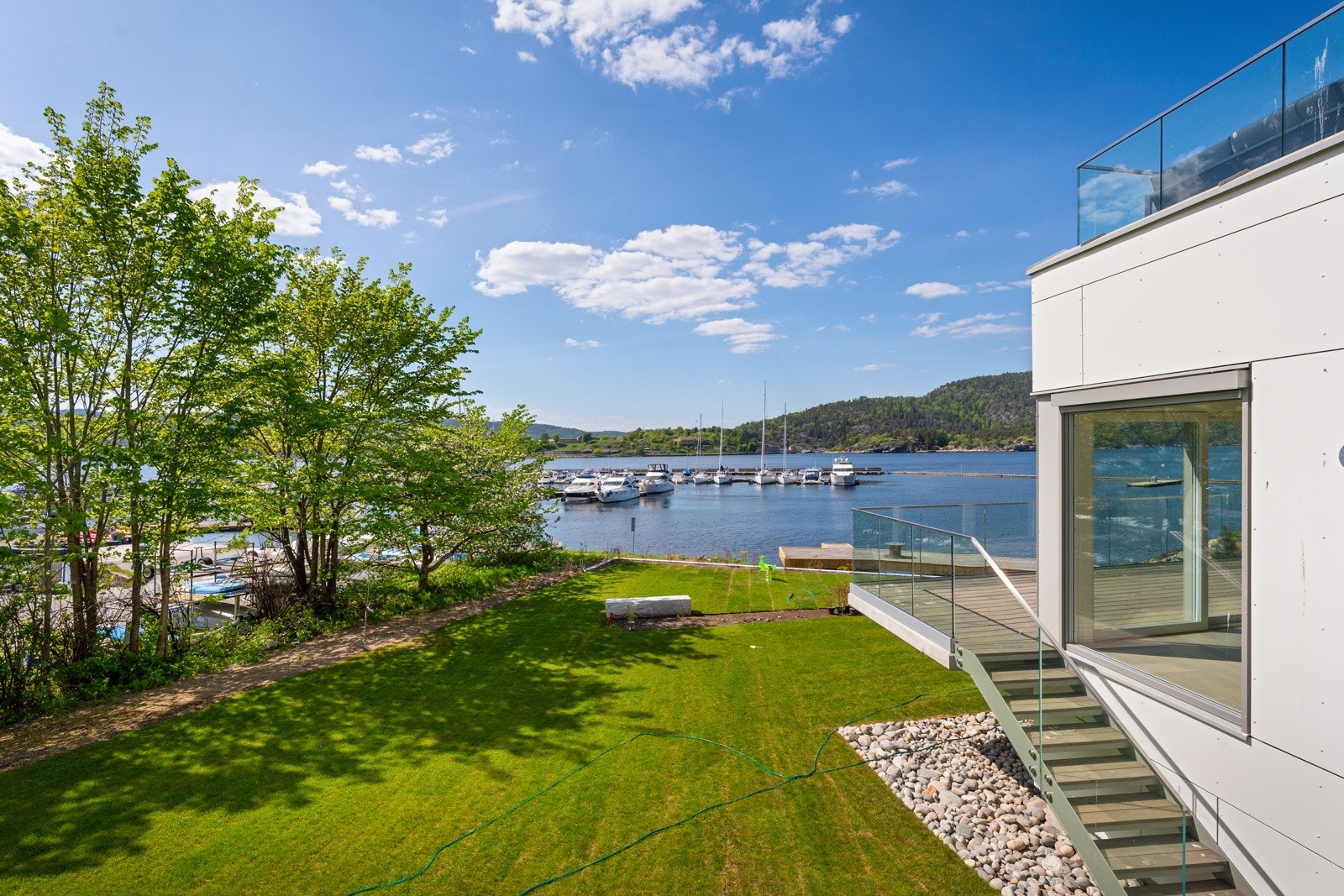 Terrasse på 36 kvm, med glassrekkverk og adkomst til hagen Galleribilde