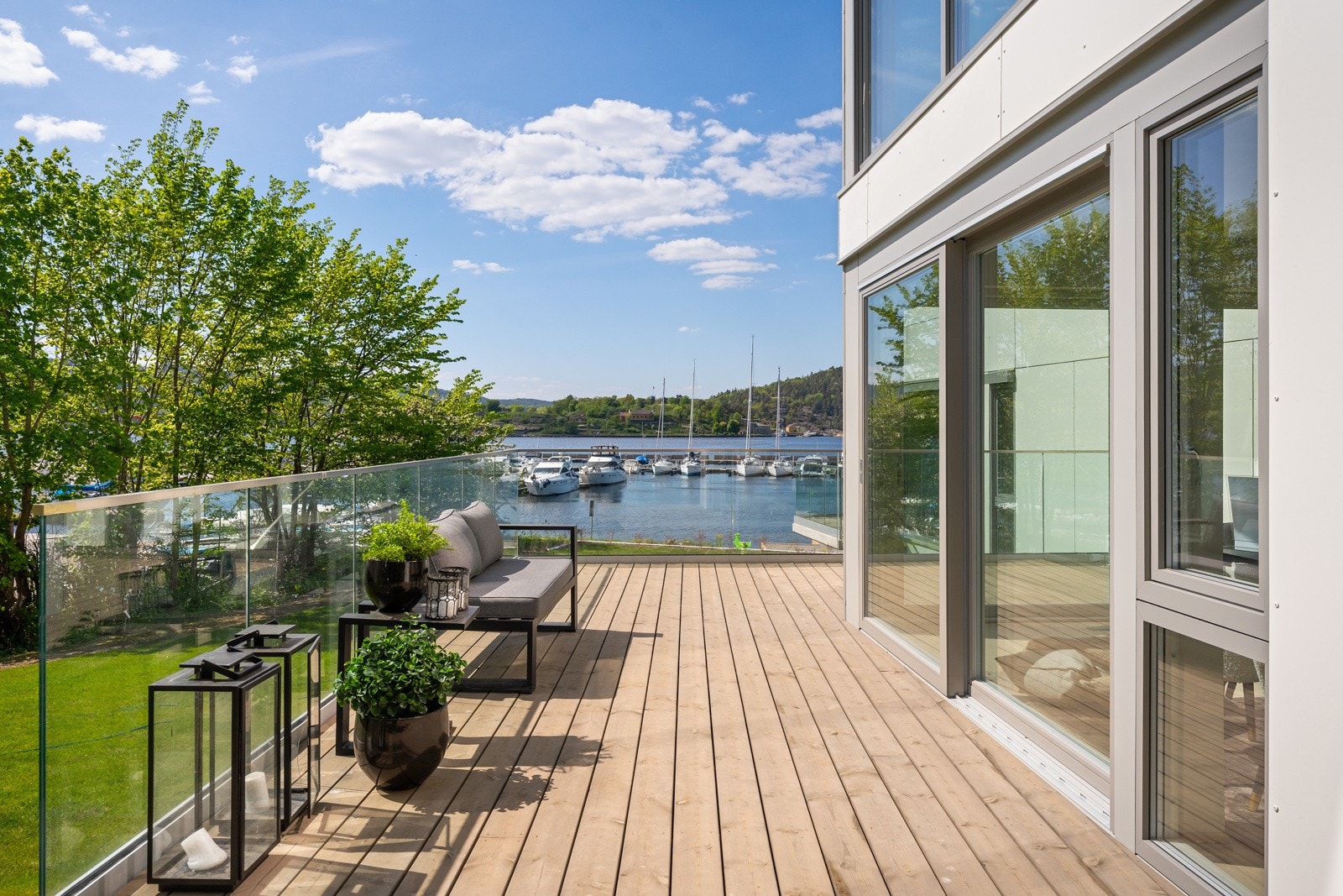 Terrasse på 36 kvm, med glassrekkverk og adkomst til hagen Galleribilde