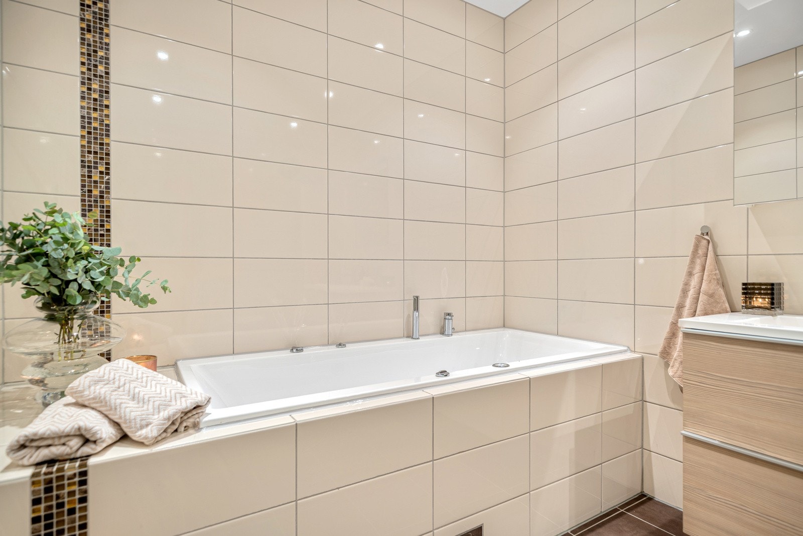 Pent flislagt og romslig baderom med boblebad, Vikingbad dusjkabinett, vegghengt klosett og innholdsrik Fossbad innredning med dobbelvask. Galleribilde