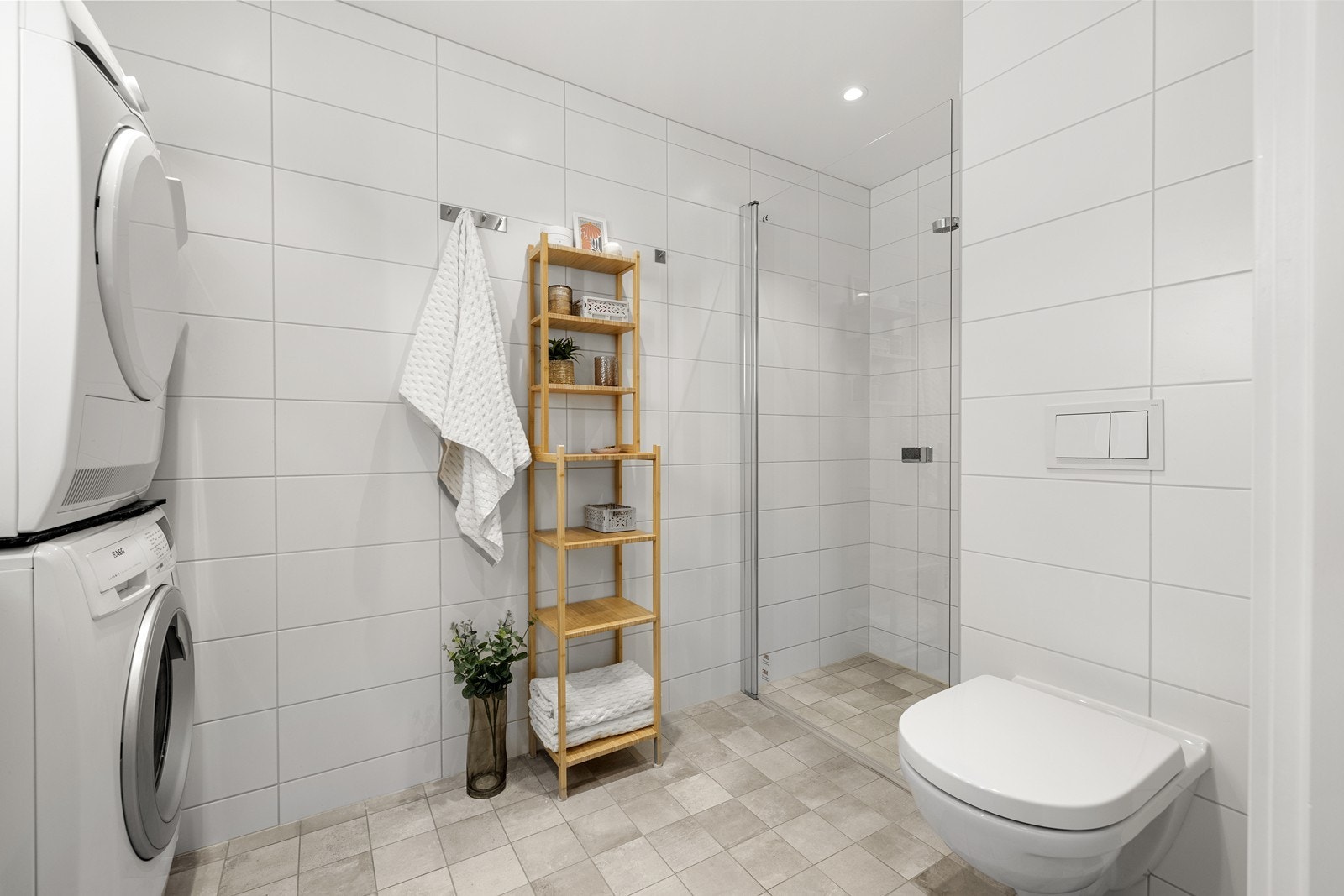 Innredningen består av underskap, nedfelt servant, speil med belysning, vegghengt toalett og dusjnisje med glassdør. Galleribilde