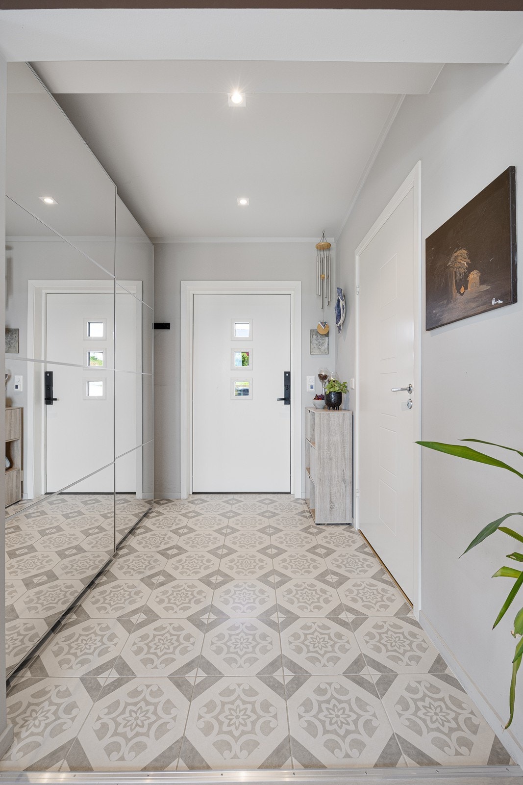 Den lekre entreen har lysmalte vegger, downlights i himlingen og mønstrede fliser på gulv med gulvvarme. Galleribilde