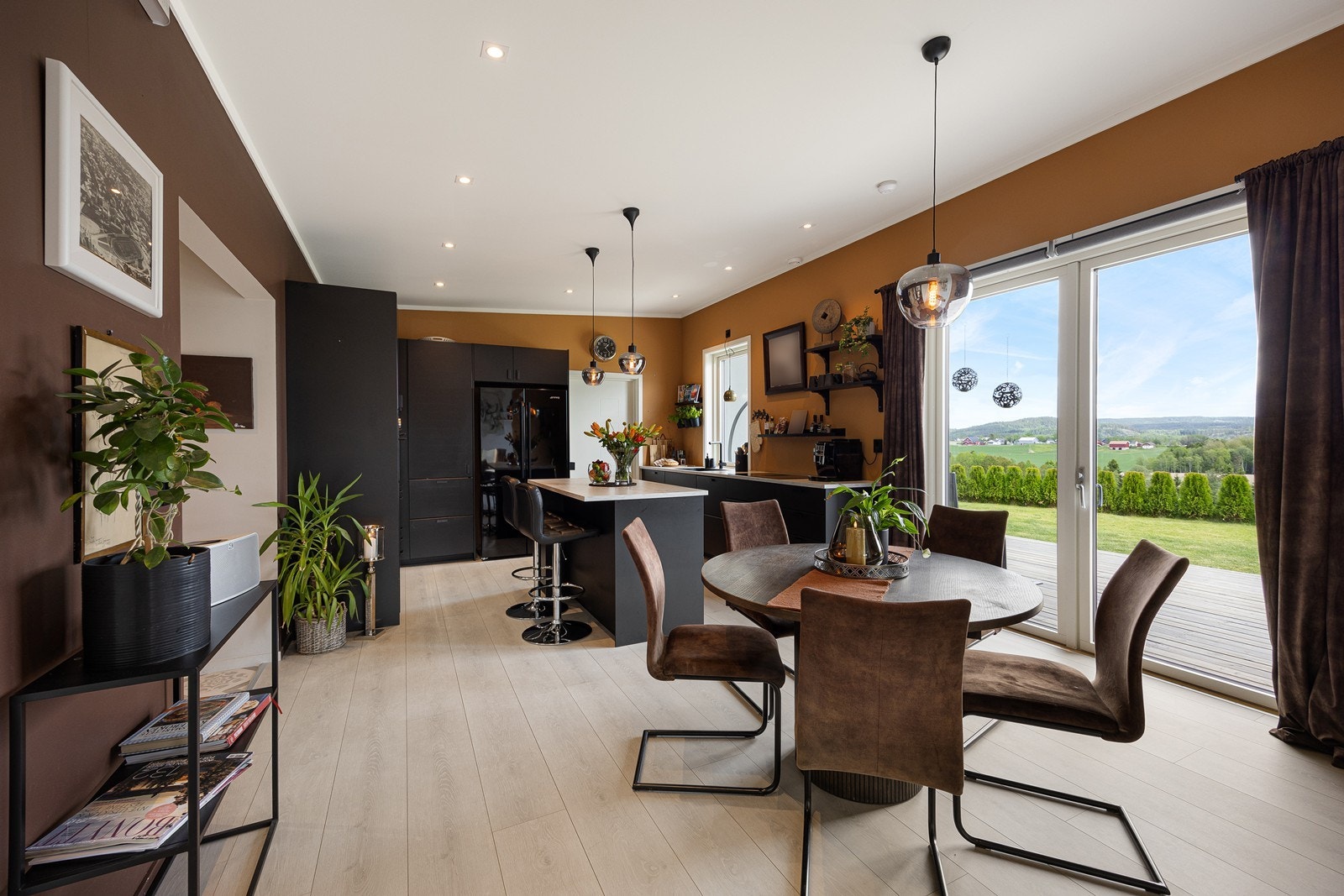 Stuen ligger i åpen løsning med kjøkken og spisestue, og sammen danner de et langstrakt, innbydende allrom med fine, definerte soner for møblering. Galleribilde