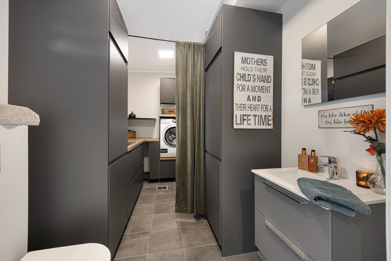 I hendig tilknytning til entreen er det et kombinert wc og vaskerom med hvitmalte vegger og grå fliser på gulv med gulvvarme. Galleribilde