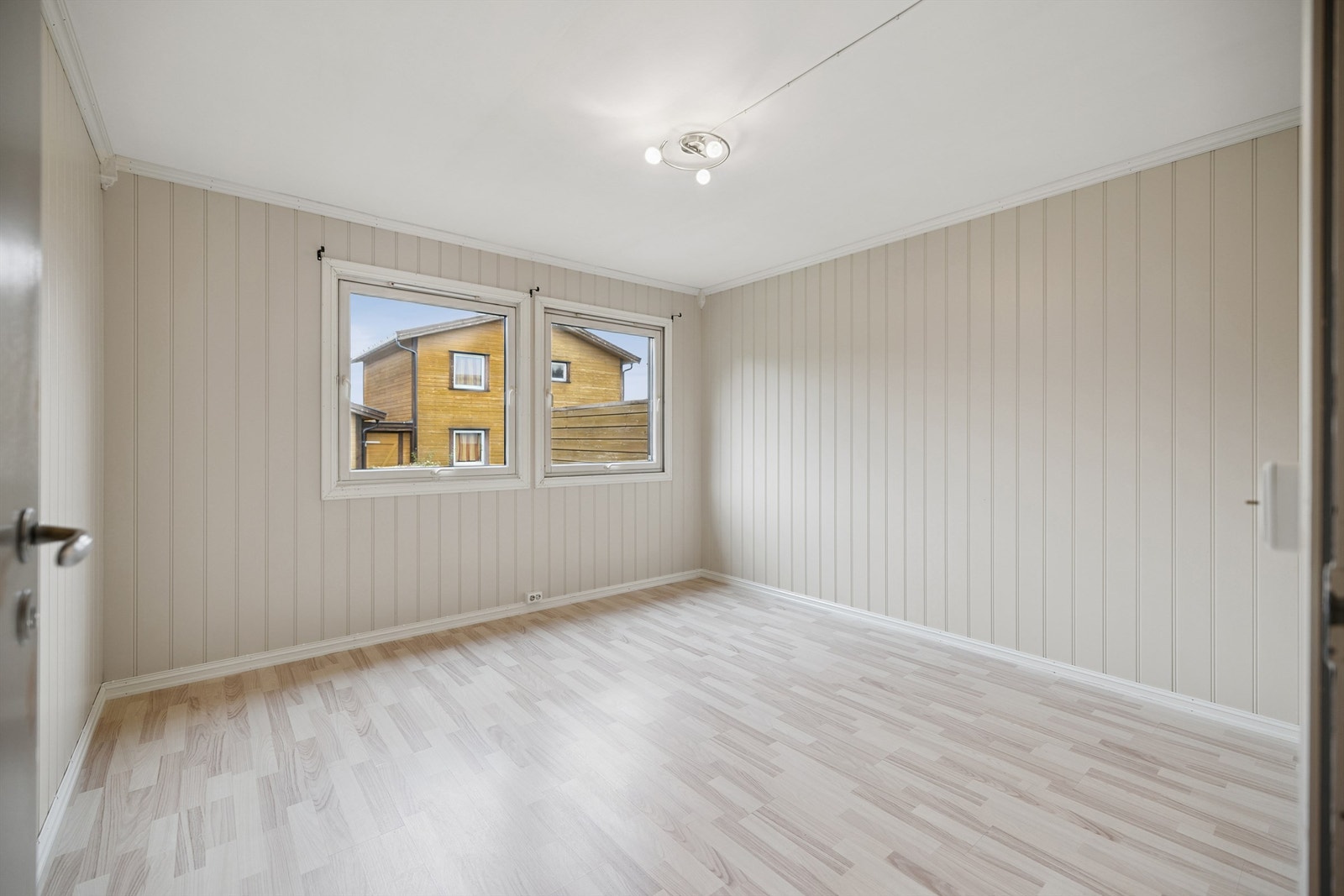 Boligens hovedsoverom er innredet med mdf-panel på vegger. To vinduer bidrar til den gode romfølelsen. Galleribilde