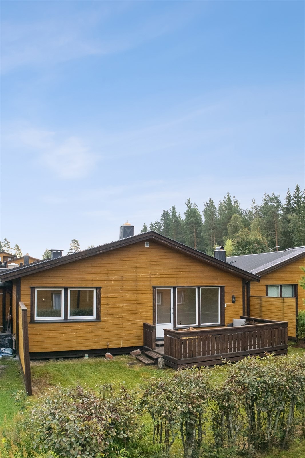 Boligens bakside med en vestvendt terrasse og utgang fra stuen. Galleribilde