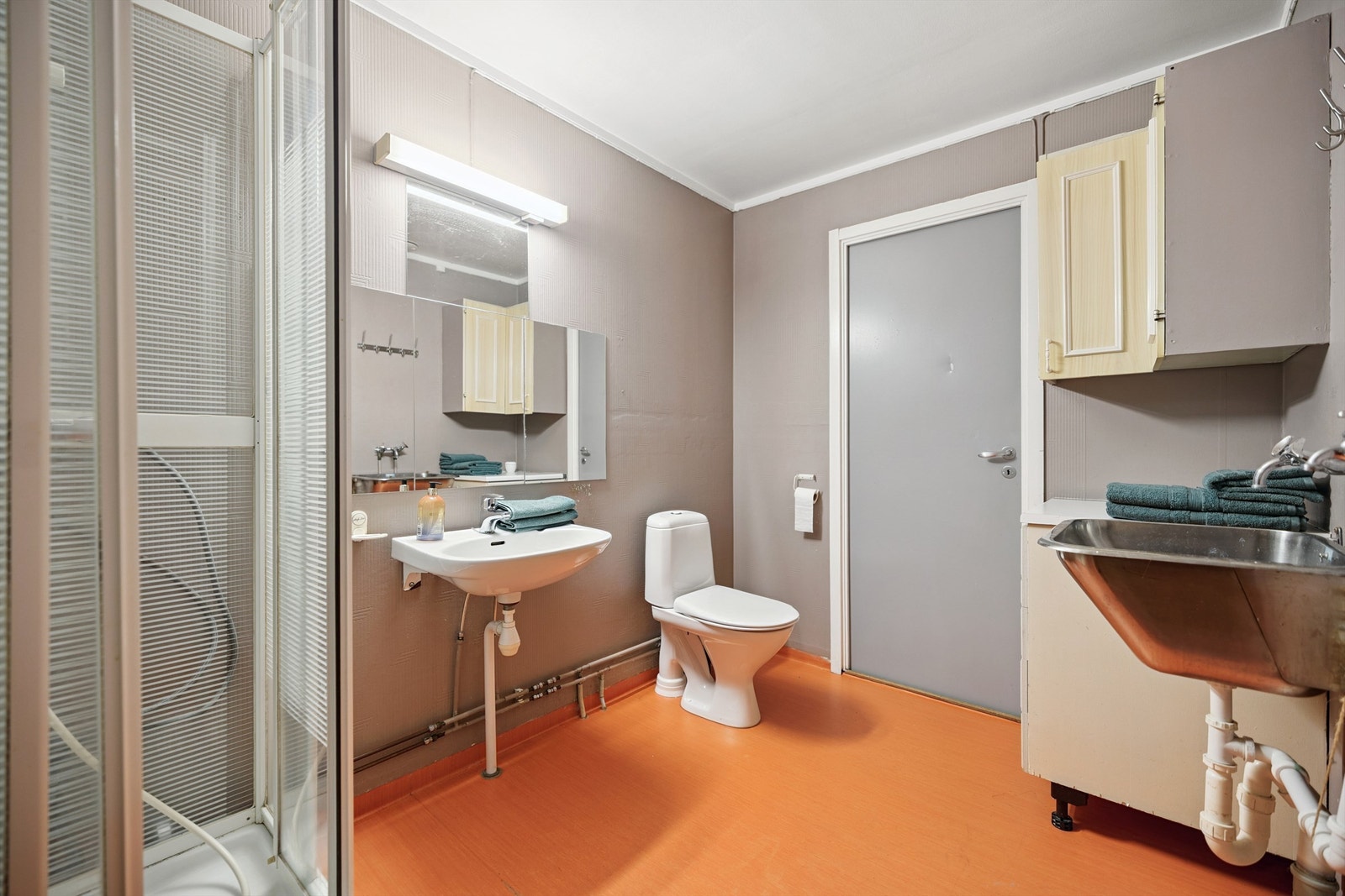 Romslig baderom med opplegg for vaskemaskin. Overflater og oppbygging fra byggeår. (TG3) Galleribilde