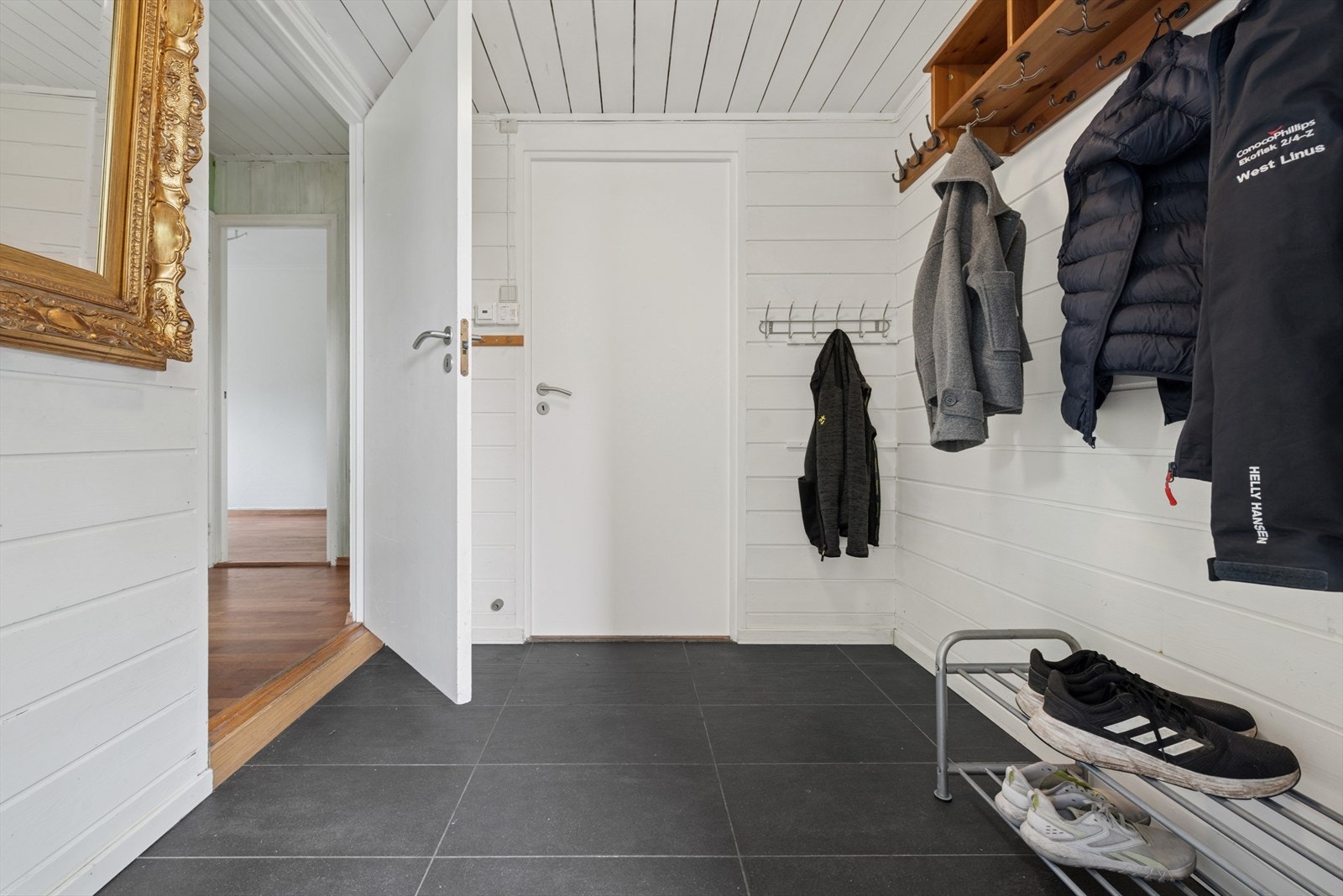 Praktisk og lys entré med god plass til oppbevaring av yttertøy og sko, med varmekabler under flisene. Galleribilde