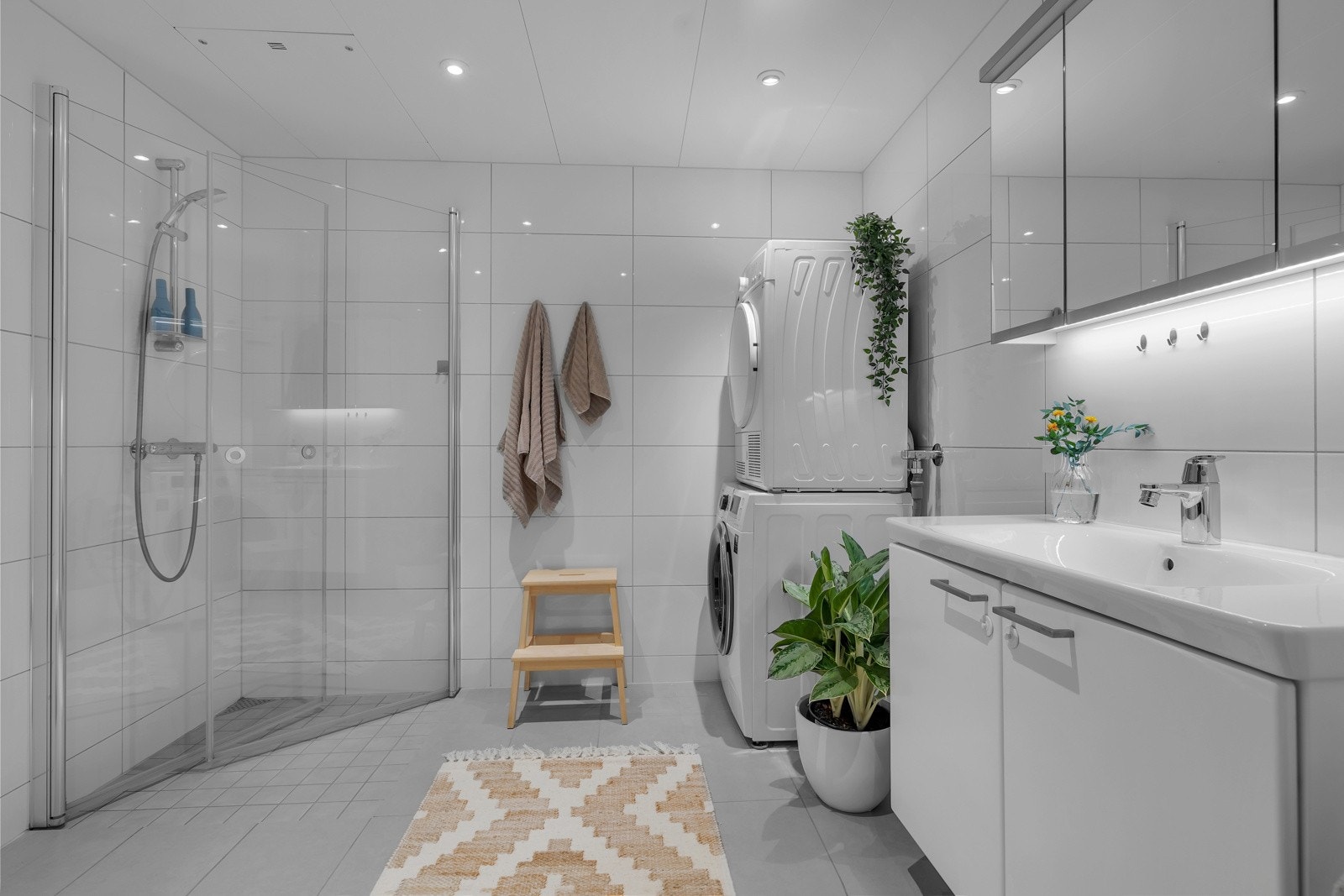 Innfelt belysning i tak, vegghengt toalett og innredning med heldekkende servant Galleribilde