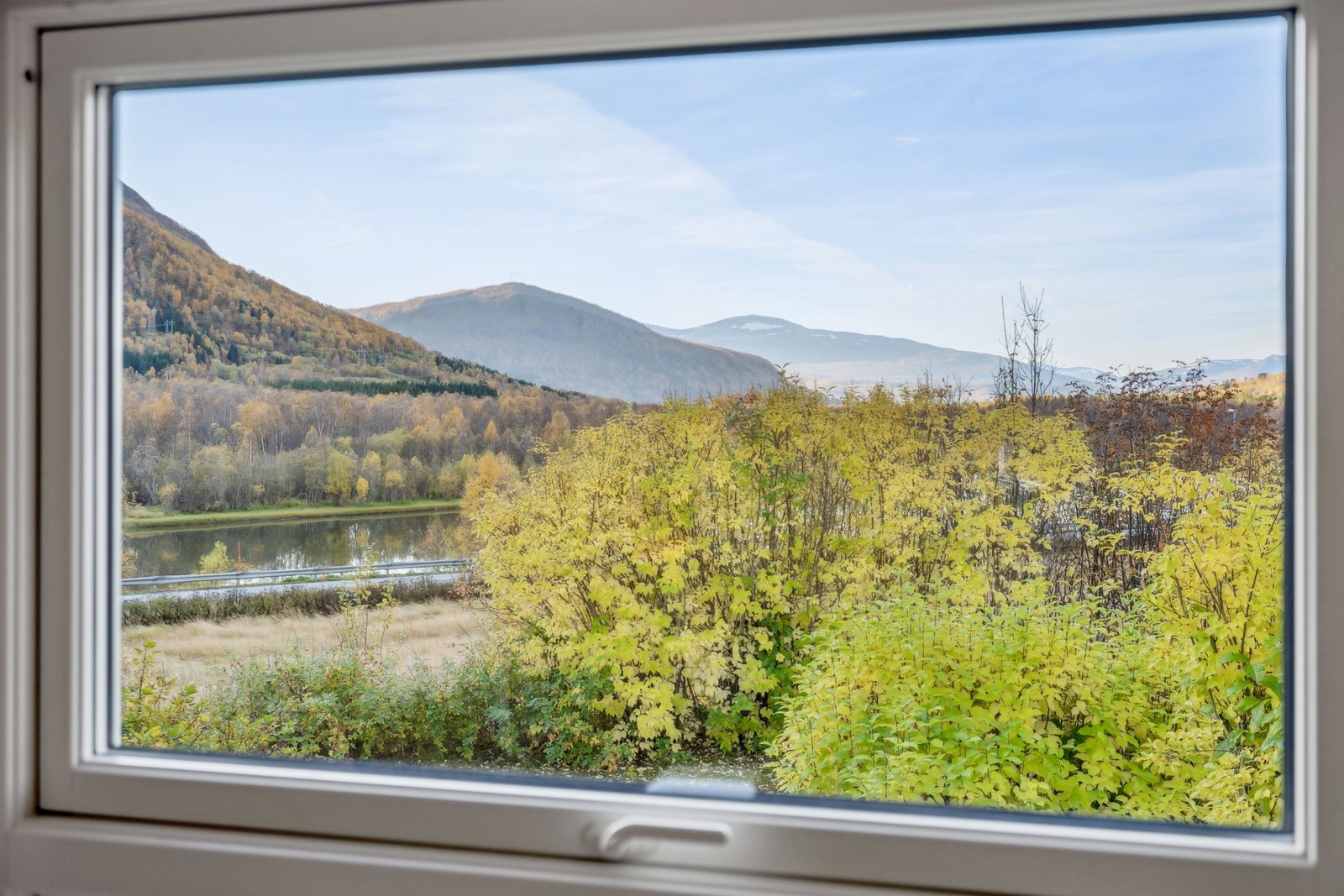 Nydelig utsikt til elv, skog og fjell fra stua. Galleribilde