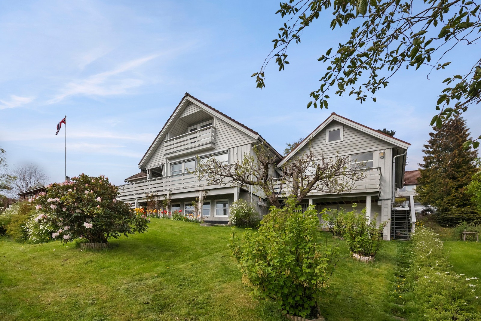 Tomten er pent opparbeidet med plenareal, frukttrær og prydbusker Galleribilde