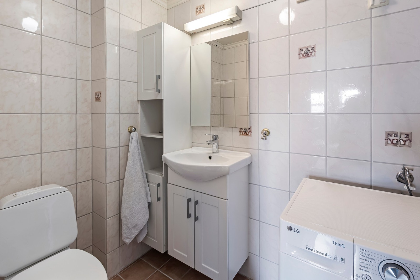 Bad/vaskerom i hybelleilighet har flislagt gulv med varmekabler. Baderomsinnredning med malte profilerte fronter, heldekkende servantplate, høyskap og speil. Nedfelt servant, toalett og dusjkabinett med glassdører montert. Opplegg for vaskemaskin Galleribilde