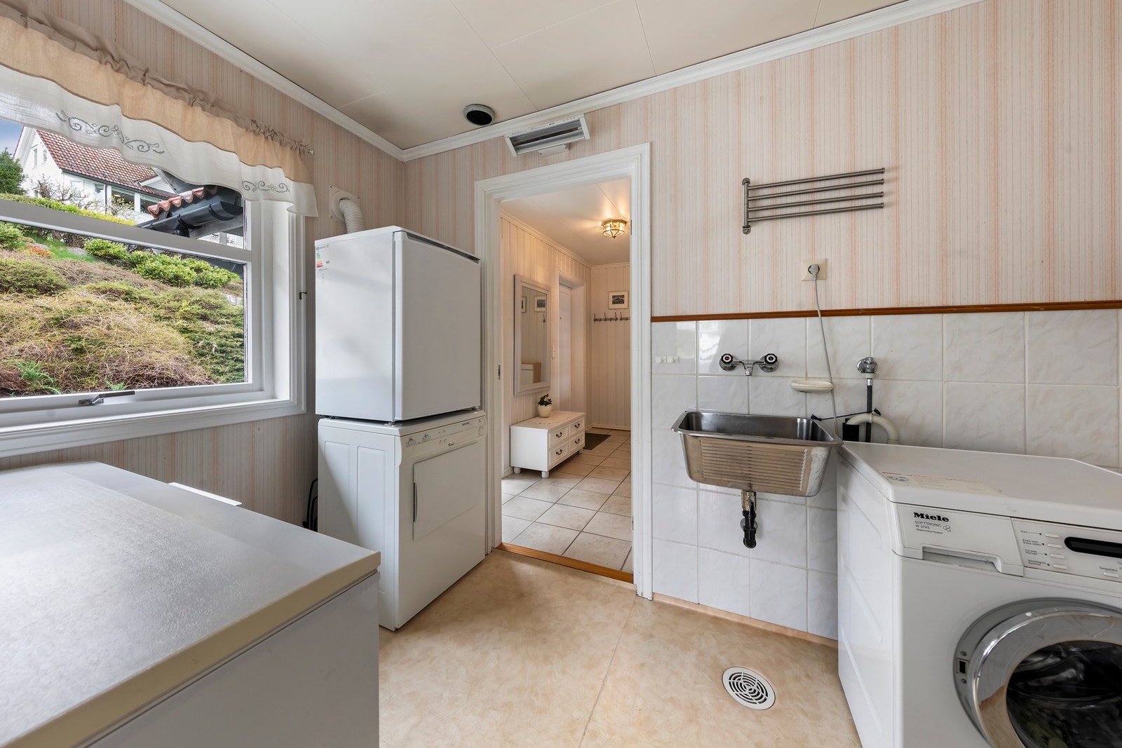 Vaskerommet med vinylbelegg og praktisk plassering med gjennomgang fra gang til kontor/kjøkken Galleribilde