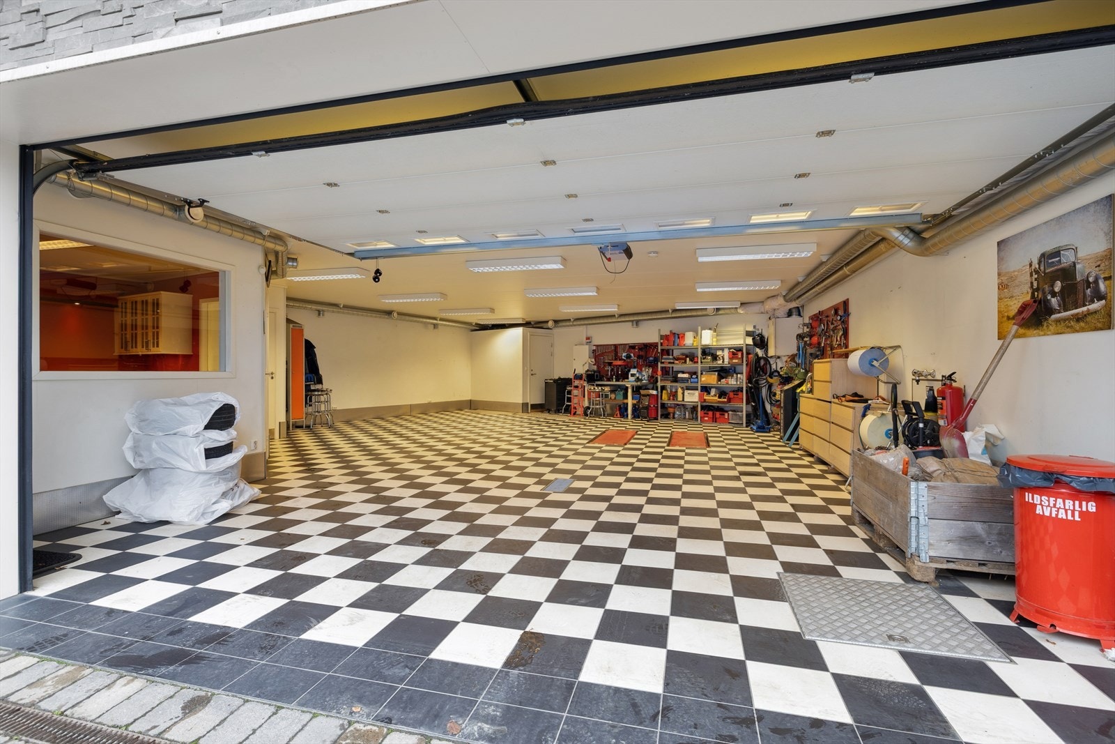 Garasjen ble oppført i 2014 og har gulv med rutemønstrede fliser for et tøft utseende. Galleribilde