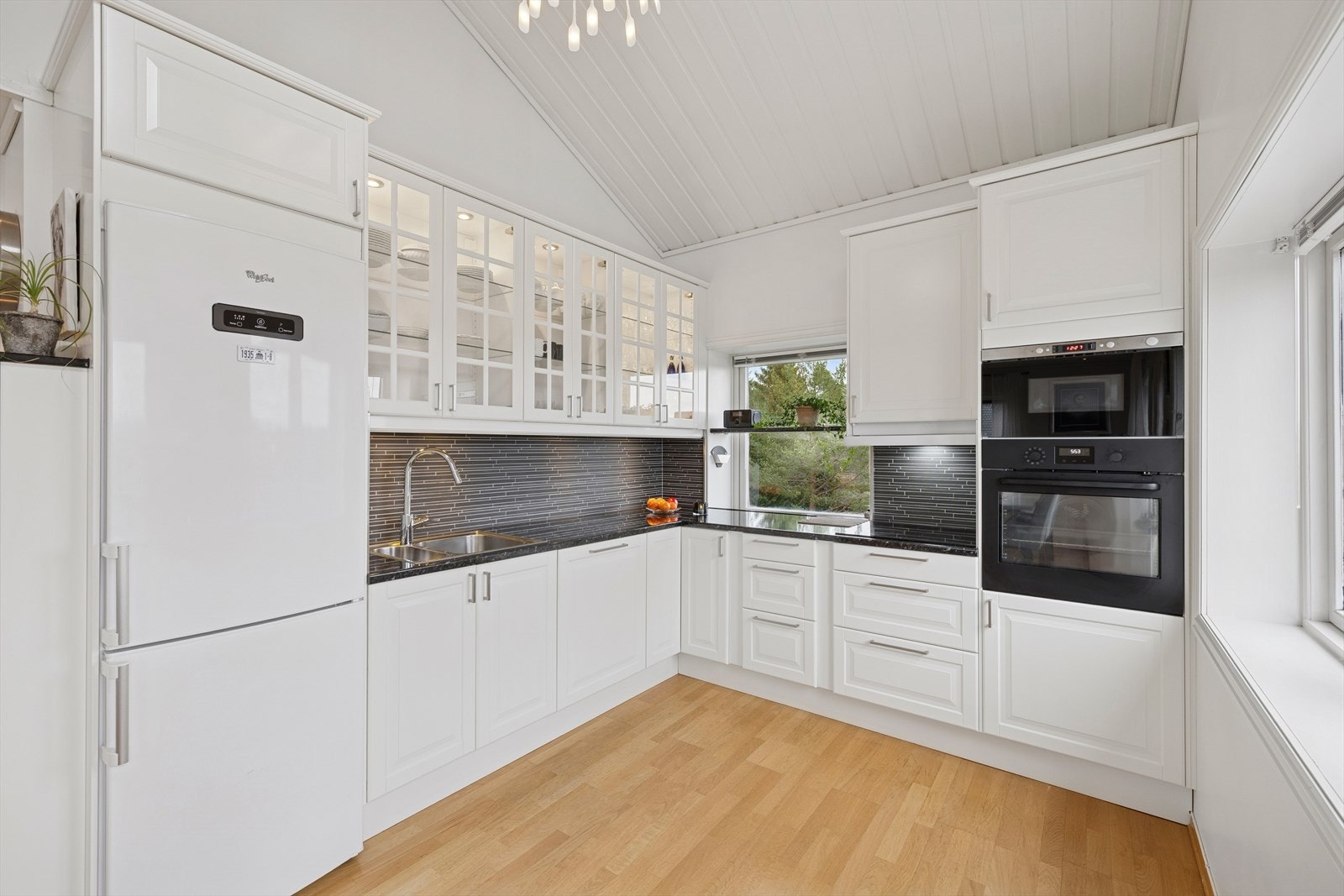 Kjøkkenet i 2. etasje har lyse profilerte fronter og integrerte hvitevarer som oppvaskmaskin, komfyr, mikro og koketopp. Galleribilde