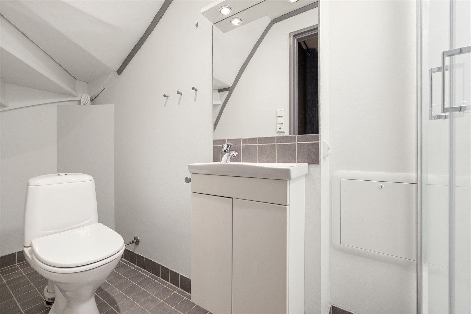 Badet ligger ved gangen med sparklede vegger og flislagt gulv med varmekabler. Galleribilde