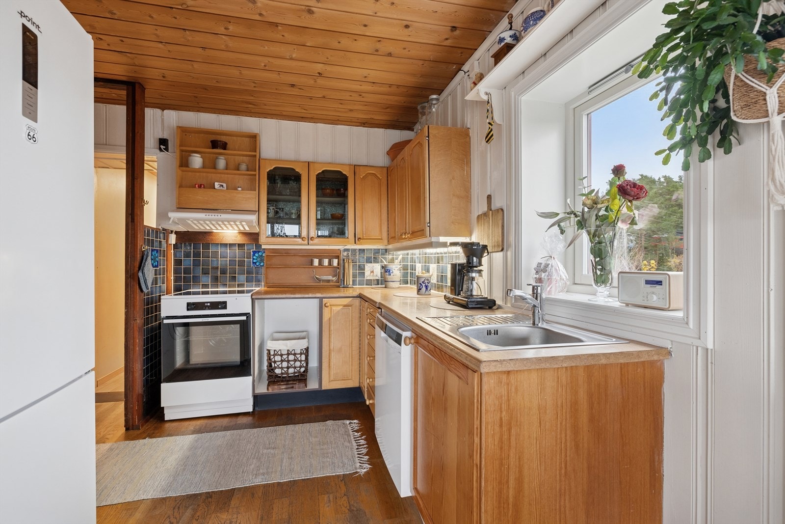 Kjøkkeninnredningen har profilerte furufronter og laminerte benkeplater med nedfelt oppvaskkum. Galleribilde