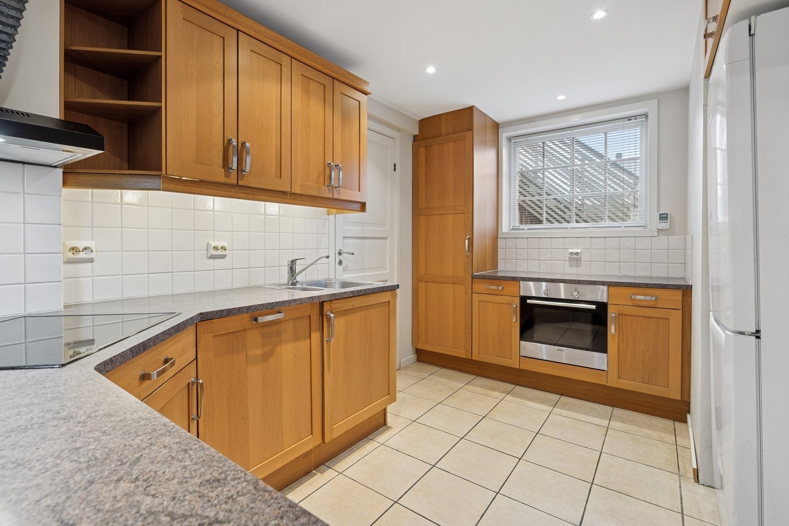 Kjøkkenet ligger i en åpen og praktisk løsning med stuen og innredning med profilerte eikefronter og laminerte benkeplater med nedfelt oppvaskkum. Galleribilde