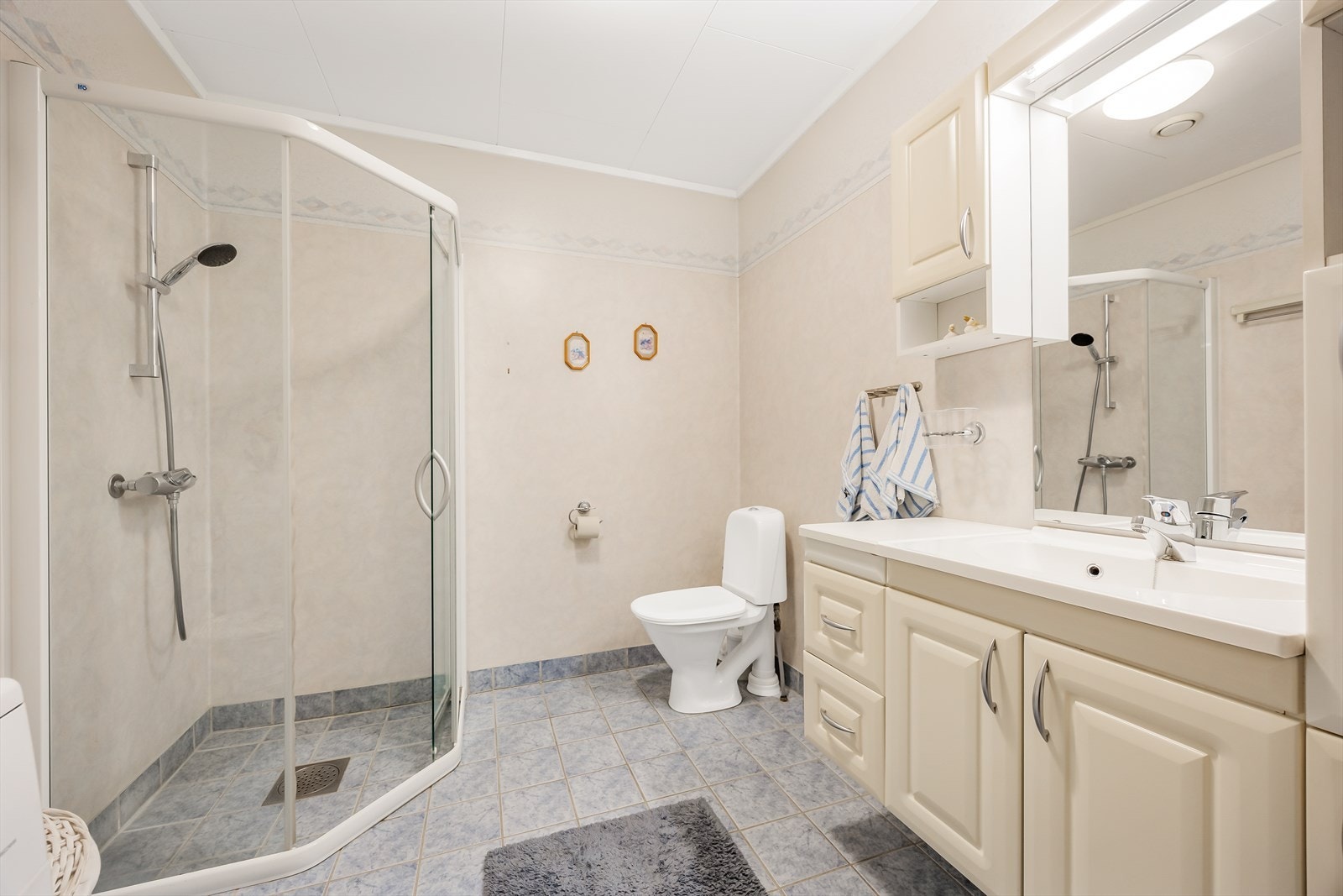 Baderom med flislagt gulv og våtromsplater på vegg. Galleribilde