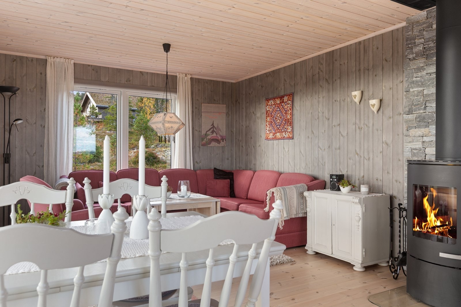 En stilfull peisovn med innsyn gir god varme på kalde vinterdager. Peisovnen har stålpipe, som også strekker seg gjennom hyttas loftstue, noe som gir rask og effektiv oppvarming til hele hytta. Galleribilde