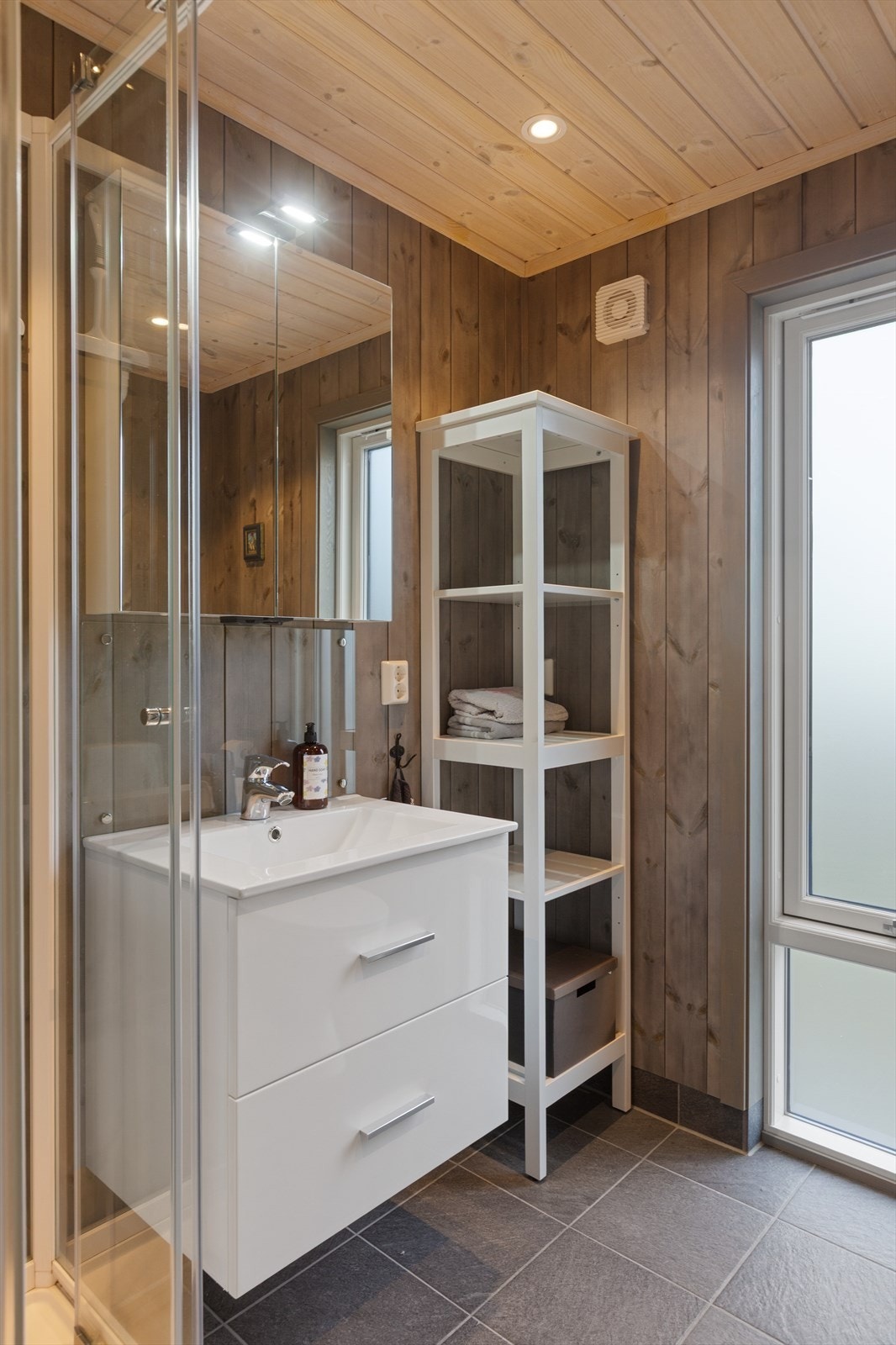 På badet er det også frittstående dusjkabinett og toalett, samt avtrekksvifte i yttervegg. Badet har, som i de flest rom i hovedetasjen, stemningsfull downlightsbelysning. Galleribilde