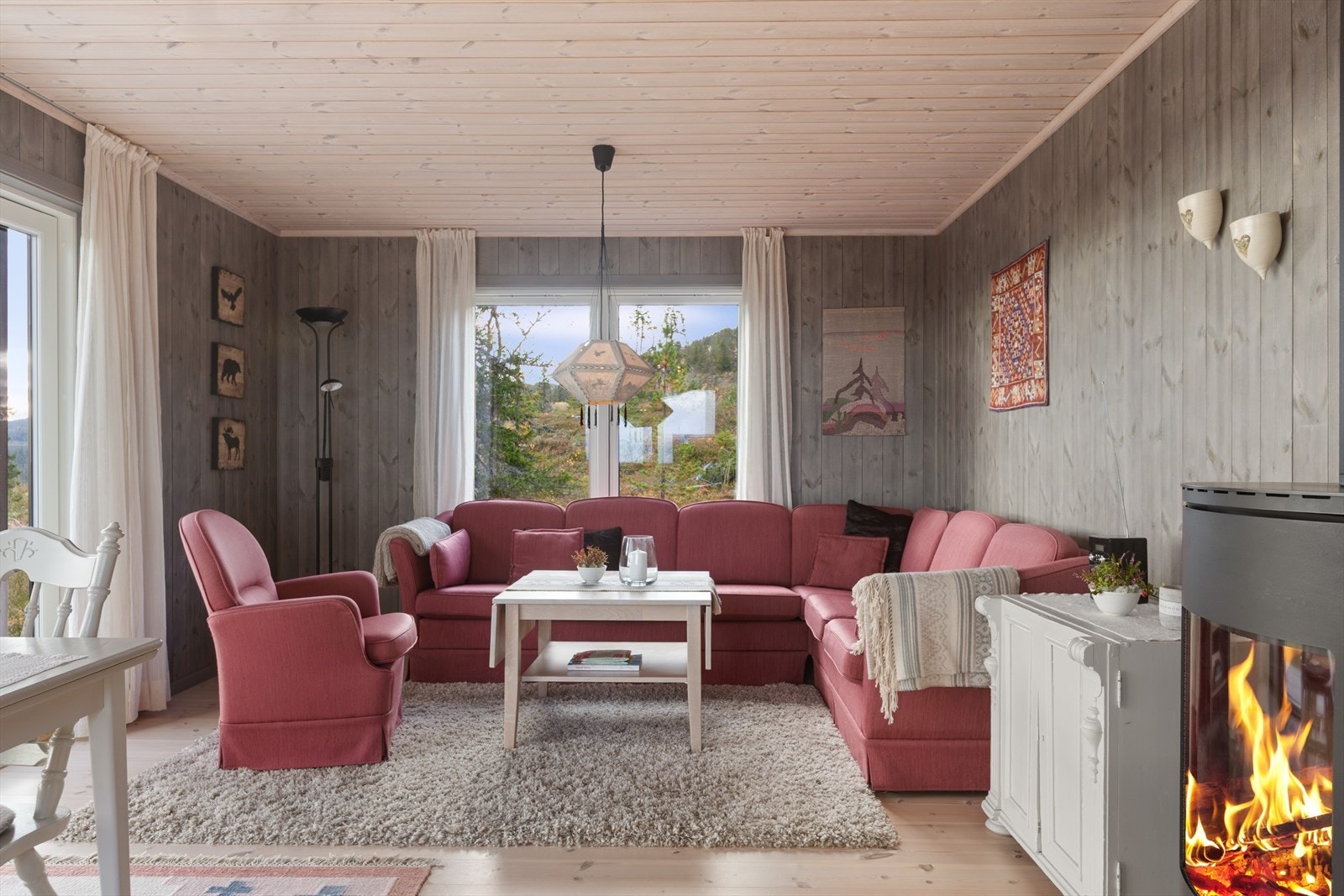 Vinduer nærmest fra gulv til tak , og et stort glassfelt i terrassedøren, gjør det enkelt å nyte naturen også inne fra sofakroken. Galleribilde