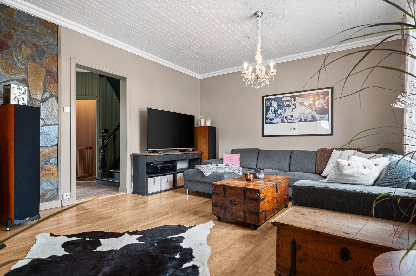 Den romslige stuen i 1. etasje. har vegger malt i en lys og dus farge. I taket er det malt panel, og på gulvet er det parkett Galleribilde