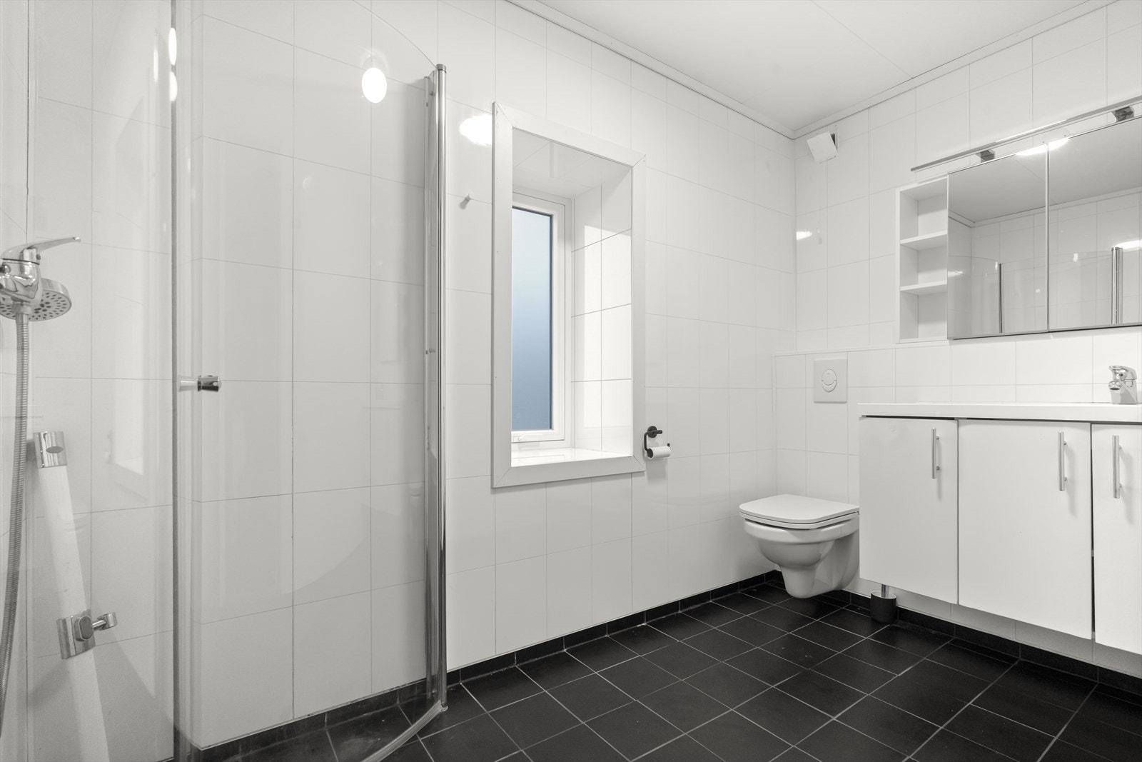 Badet har flislagt golv med varmekablar og baderomsplater på veggane Galleribilde