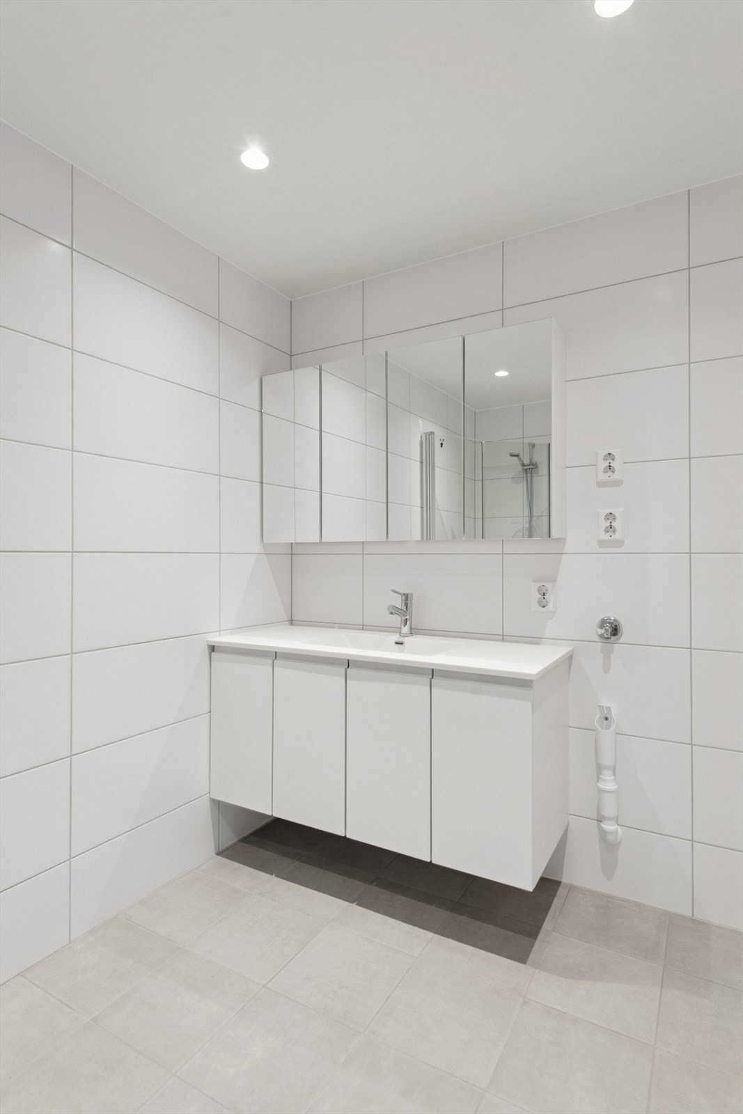 Badet er utstyrt med servant med underskap, speilskap, dusjhjørne, toalett og opplegg for vaskemaskin. Galleribilde