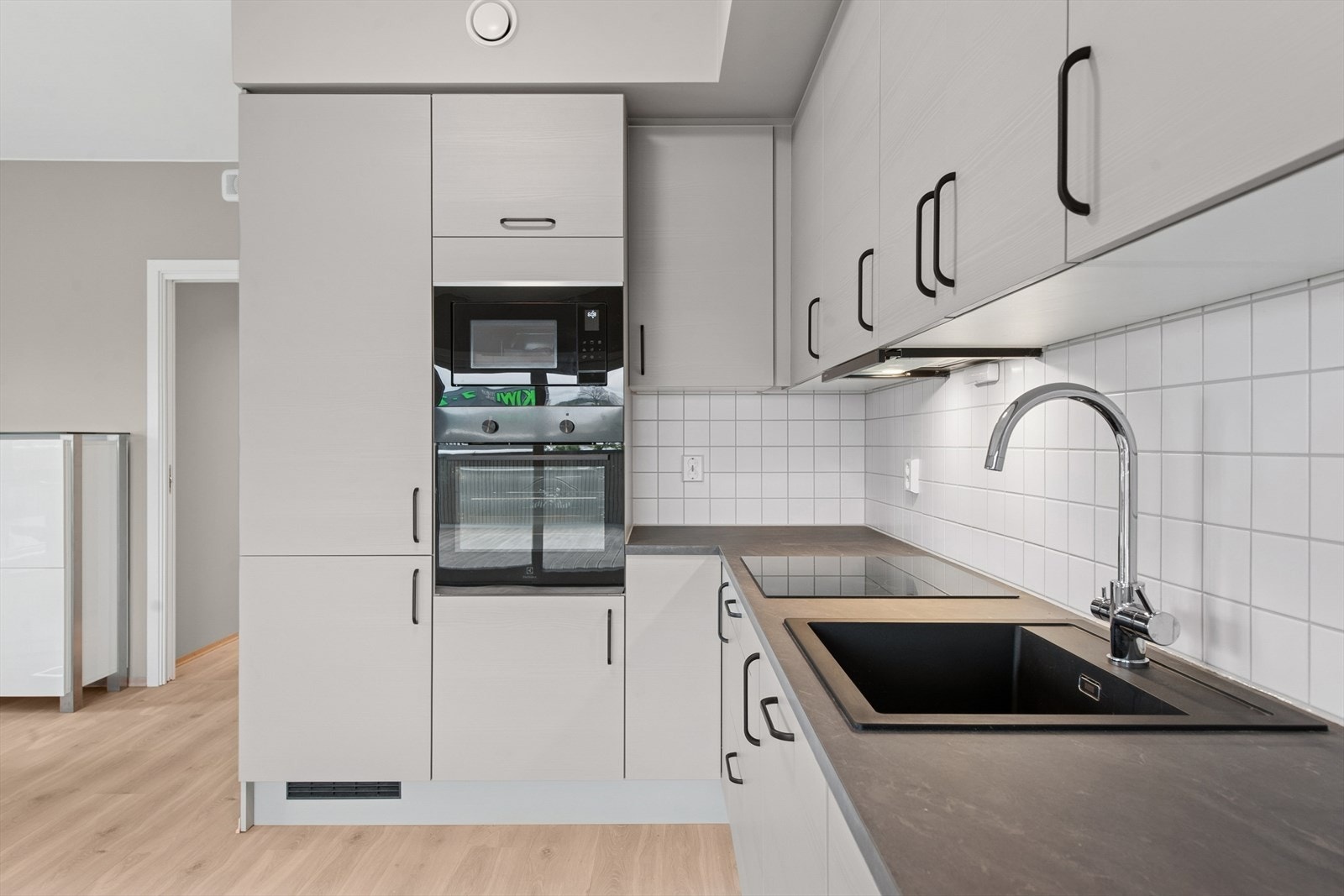 Lekkert og moderne kjøkken i åpen løsning mot stue. Galleribilde