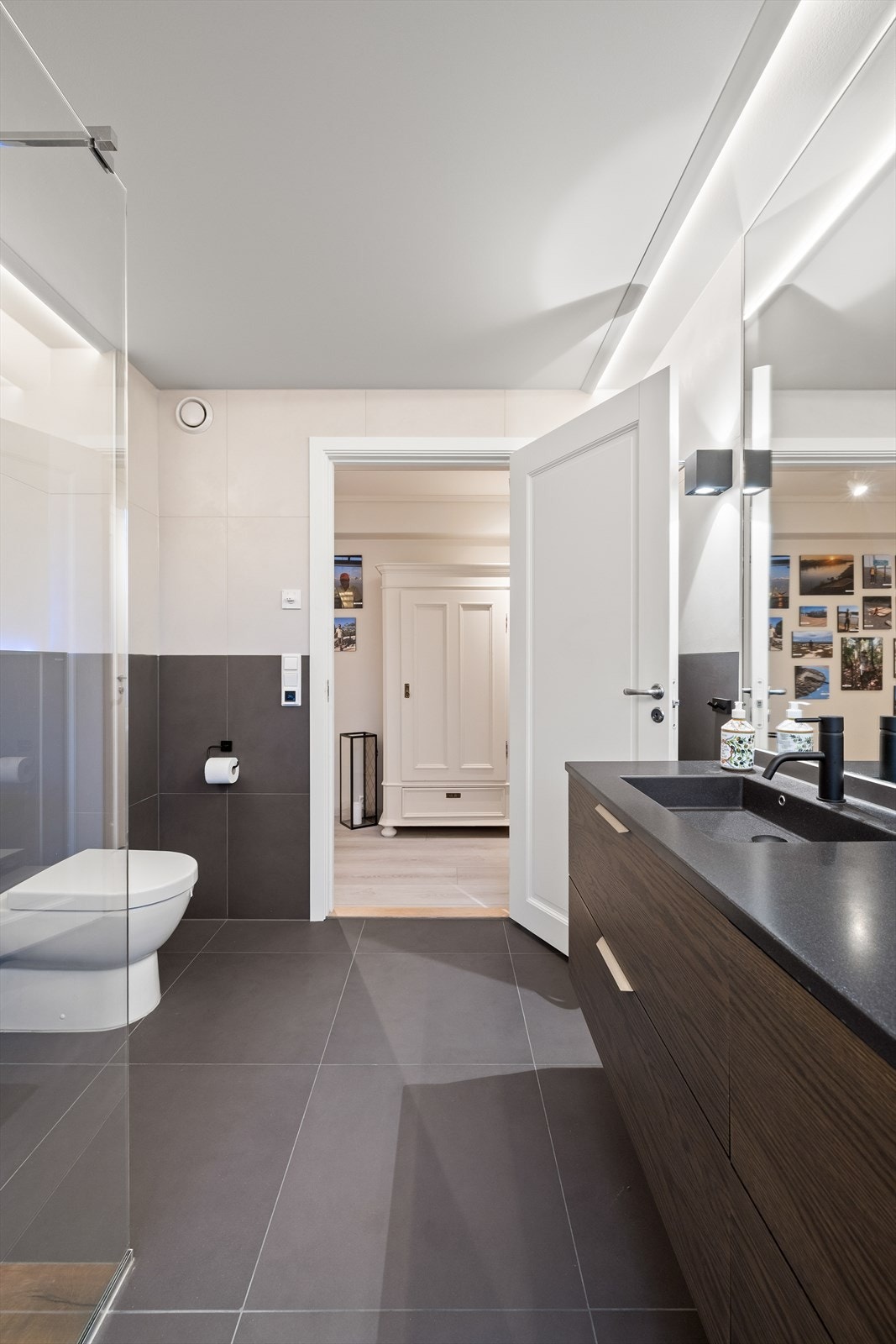 Badet er innredet med veggmontert toalett, dusjvegger/hjørne og innredning med 2 nedfelte servanter Galleribilde