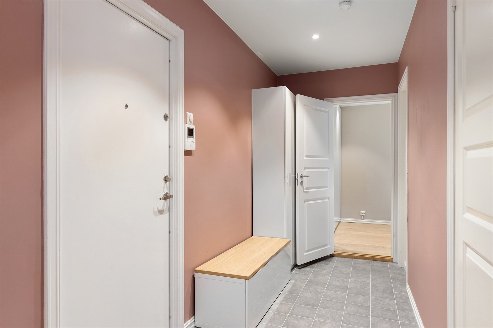 Praktisk entré med flislagt gulv og garderobeskap Galleribilde