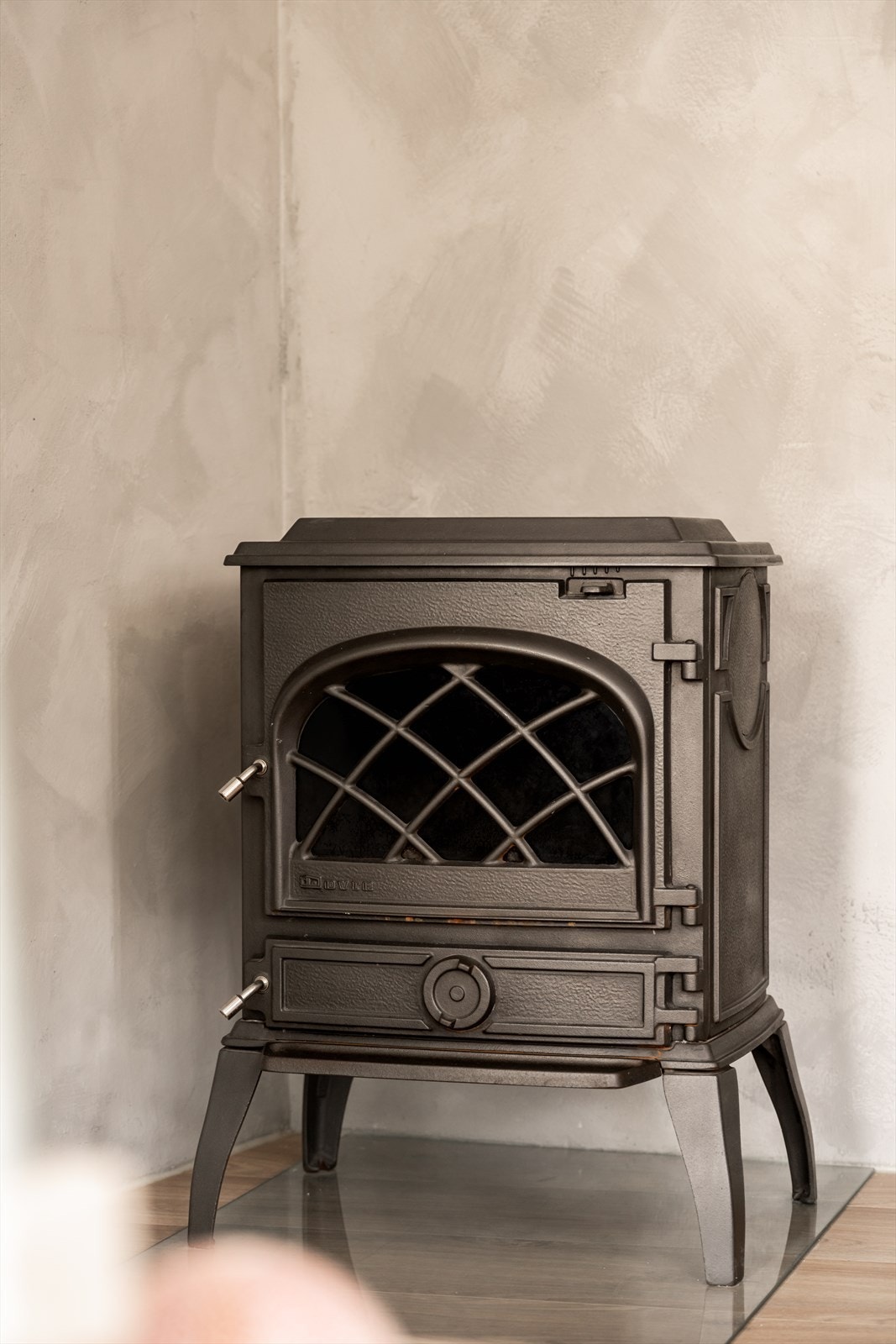 En klassisk vedovn gir både varme og en hyggelig atmosfære. I tillegg er det montert en moderne Adax Neo Wifi-panelovn (2020 i stuen. Galleribilde