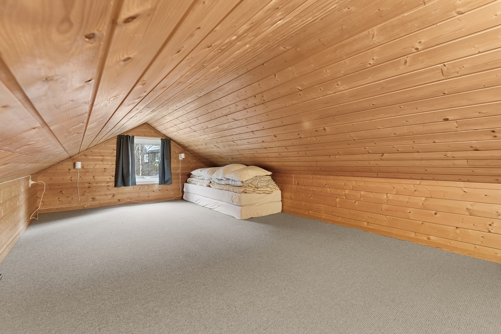 Fra stuen har man tilkomst til en hems som passer ypperlig som ekstra tv-krok eller lekerom for de minste i familien. Galleribilde