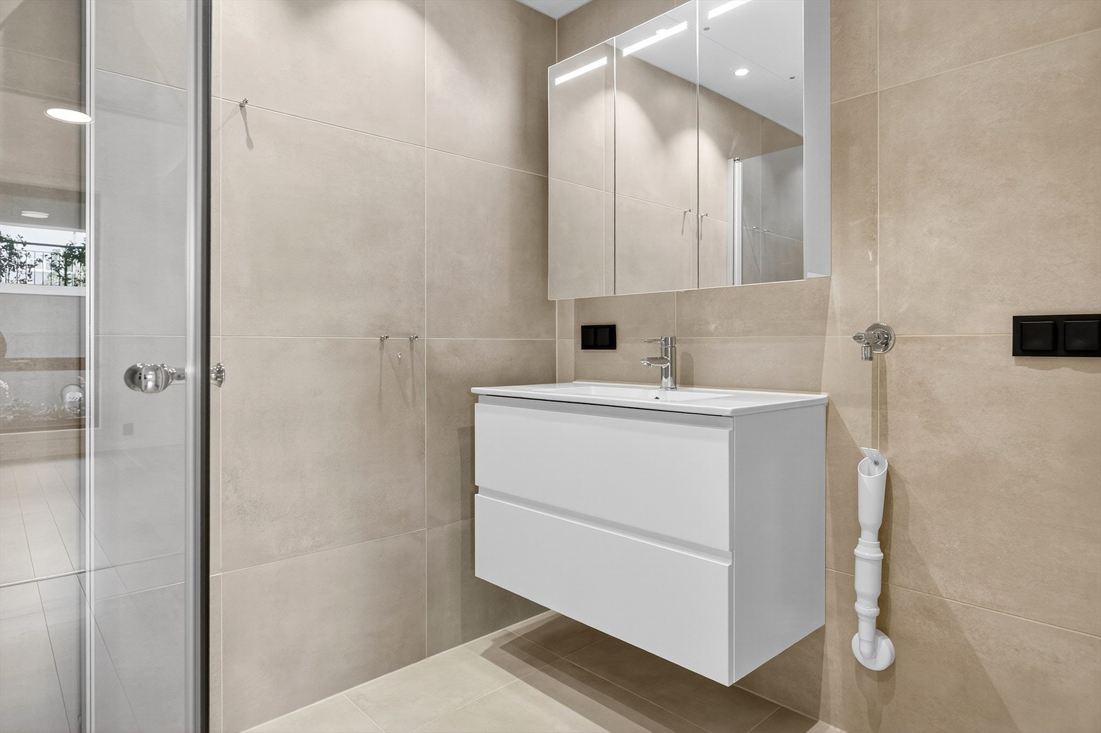 Moderne baderom med gjennomtenkte detaljer. Badet er en prefabrikert baderomskabin fra 2023 med flislagt gulv og vegger, samt varmekabler for komfort. Galleribilde