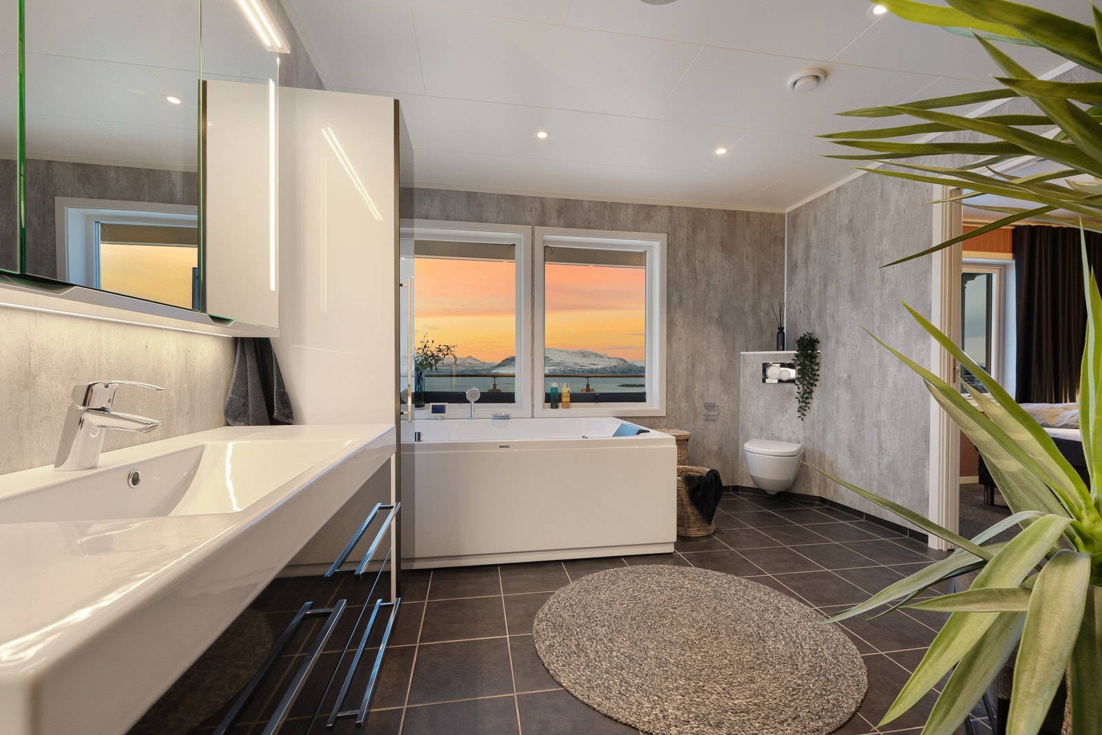 Hovedbadet byr på god komfort og har alt du trenger - vegghengte innredninger og toalett, dusjhjørne og badekar Galleribilde