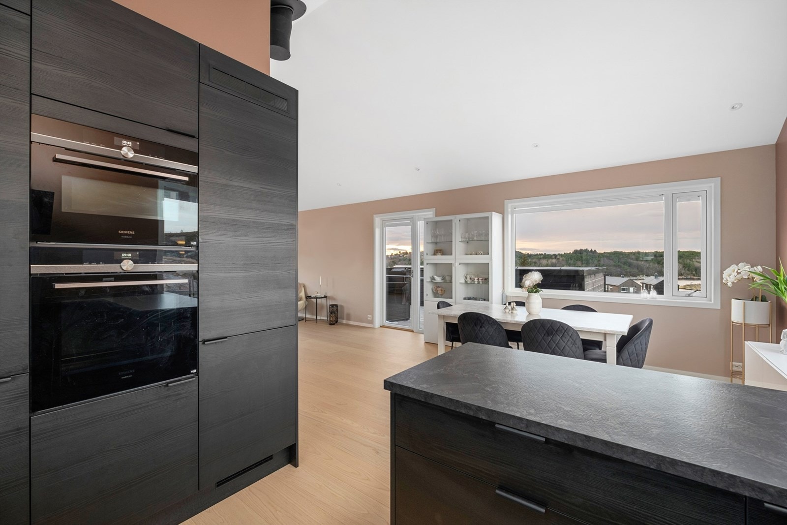 Elegant kjøkken med rene linjer, integrerte hvitevarer og god benkeplass til kokkelering. Galleribilde