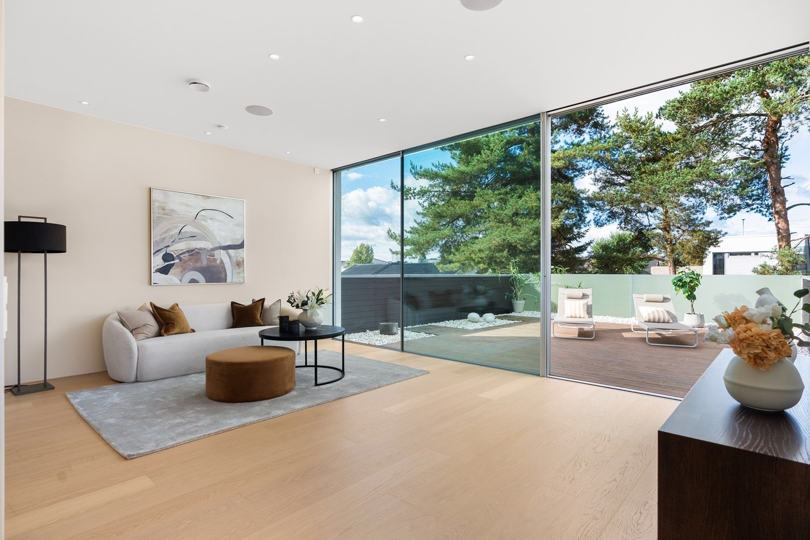 Boligens andre stue er romslig og innbydende, med store vindusflater som slipper inn rikelig med dagslys og skaper en sømløs overgang mellom inne og ute. Galleribilde