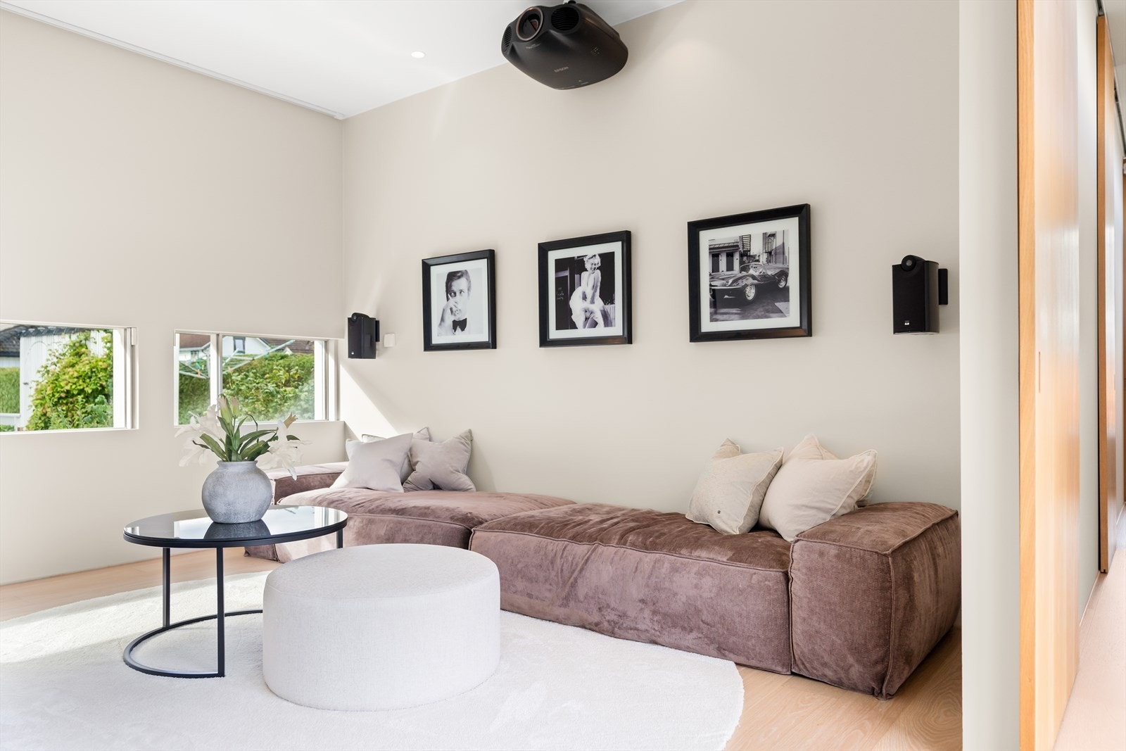 En kombinasjon avpass til avansert kinoskjerm, store vinduer som slipper inn rikelig dagslys, og skaper en elegant og stilren ramme for underholdning og avslapning. Galleribilde