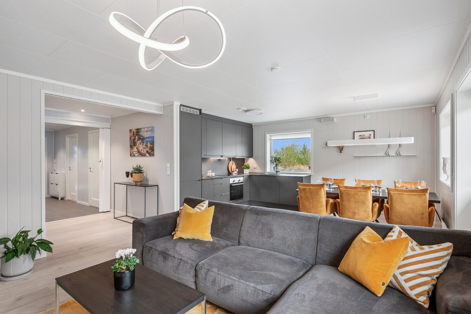 Store vindusflater og gjennomgående lyse og moderne laminatgulv skaper en helhetlig og luftig atmosfære. Galleribilde