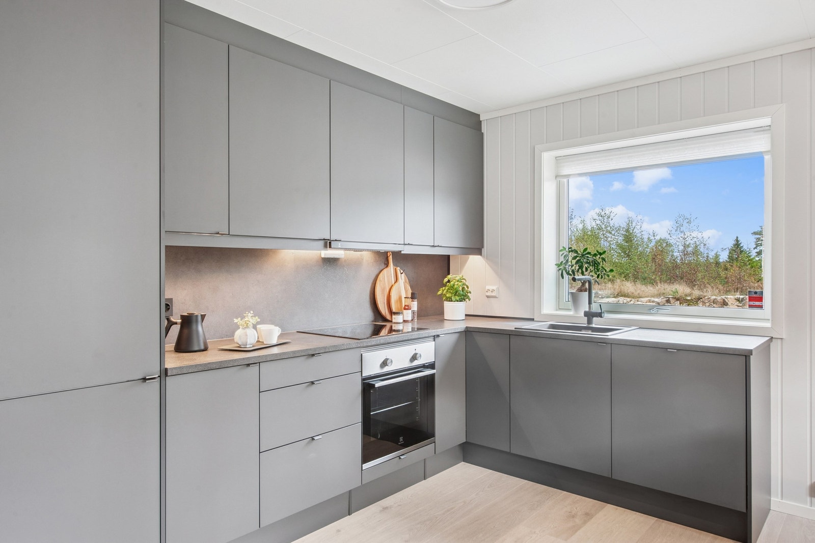 Moderne kjøkkeninnredning med glatte fronter, laminat benkeplate og integrerte hvitevarer. Galleribilde