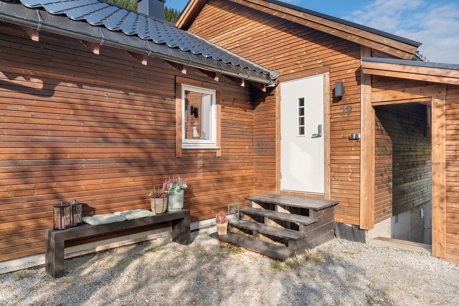 Hytta har lett tilkomst frå bakkeplan via ei lita trapp. Like ved inngangen er det også ei praktisk utebod. Galleribilde