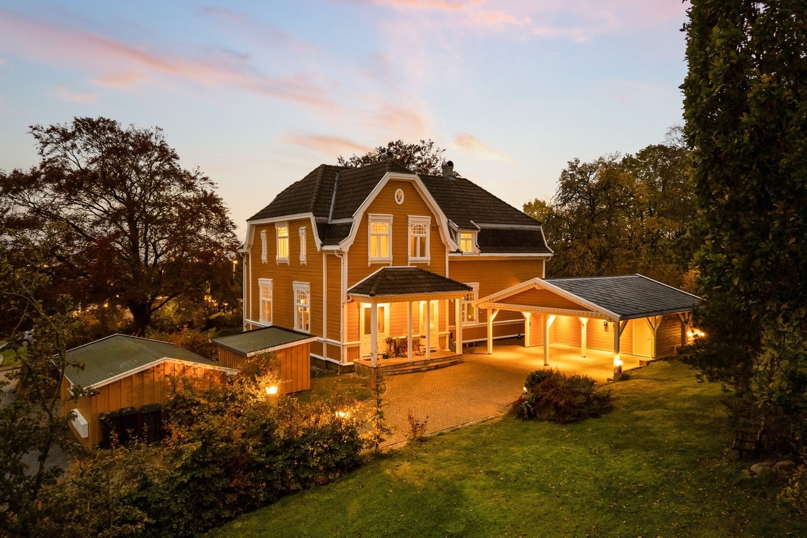 Den klassiske hagen omfavner huset med gamle trær, blomstring og brosteinsbelagt gårdsplass. Galleribilde